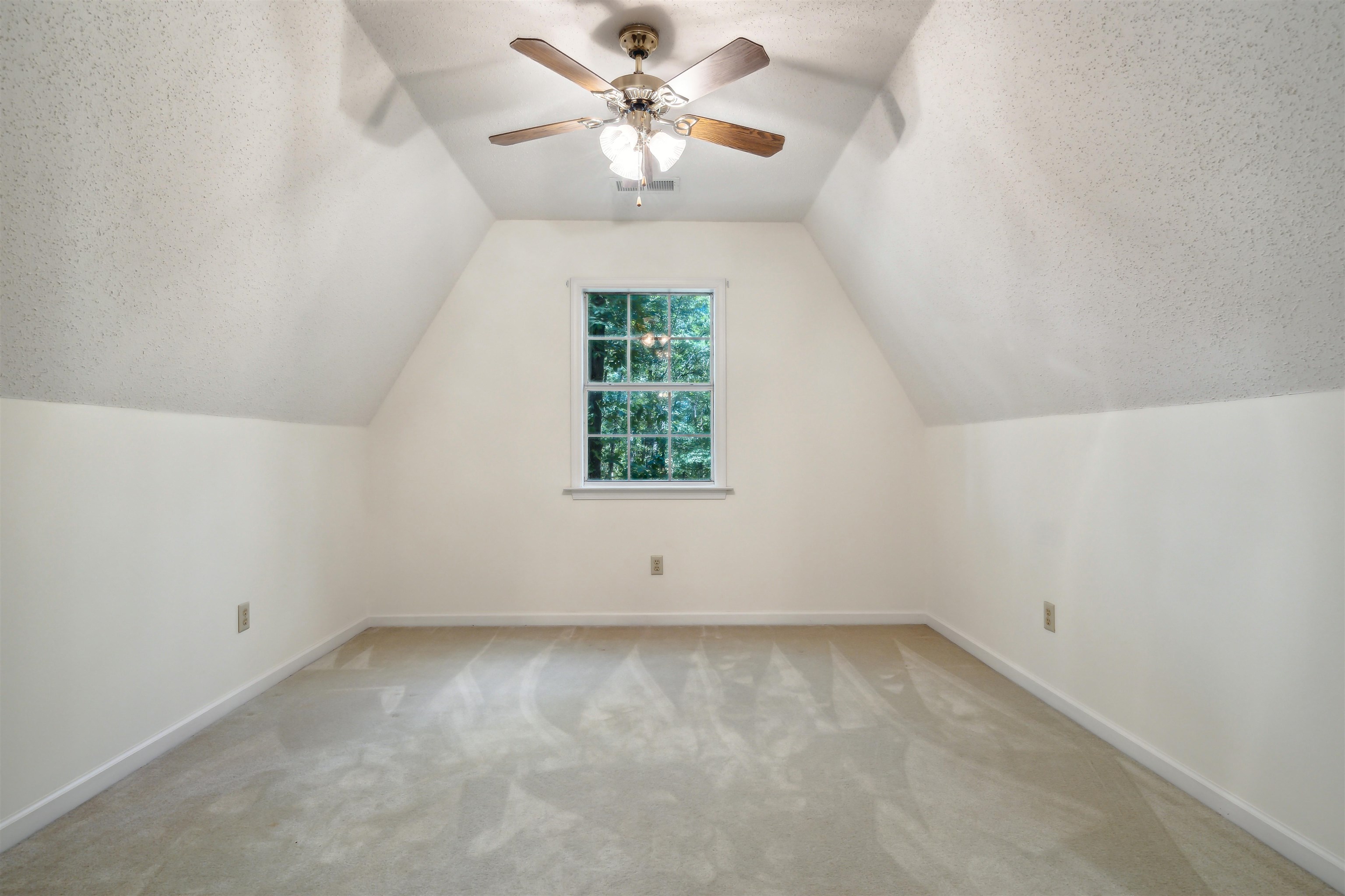 Additional living space with ceiling fan, light colored carpet, a textured ceiling, and vaulted ceiling