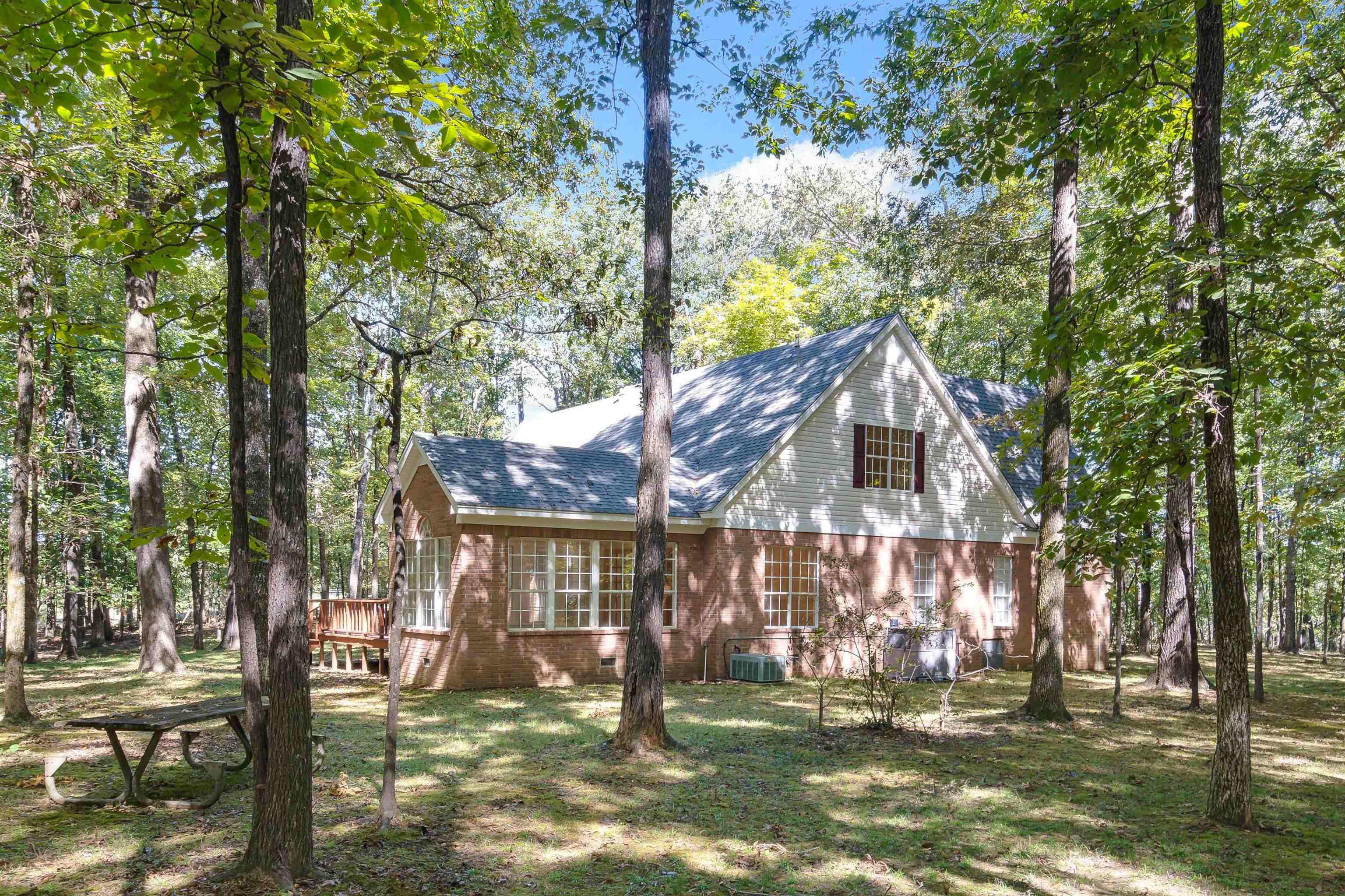View of property exterior with central air condition unit, a deck, and a yard