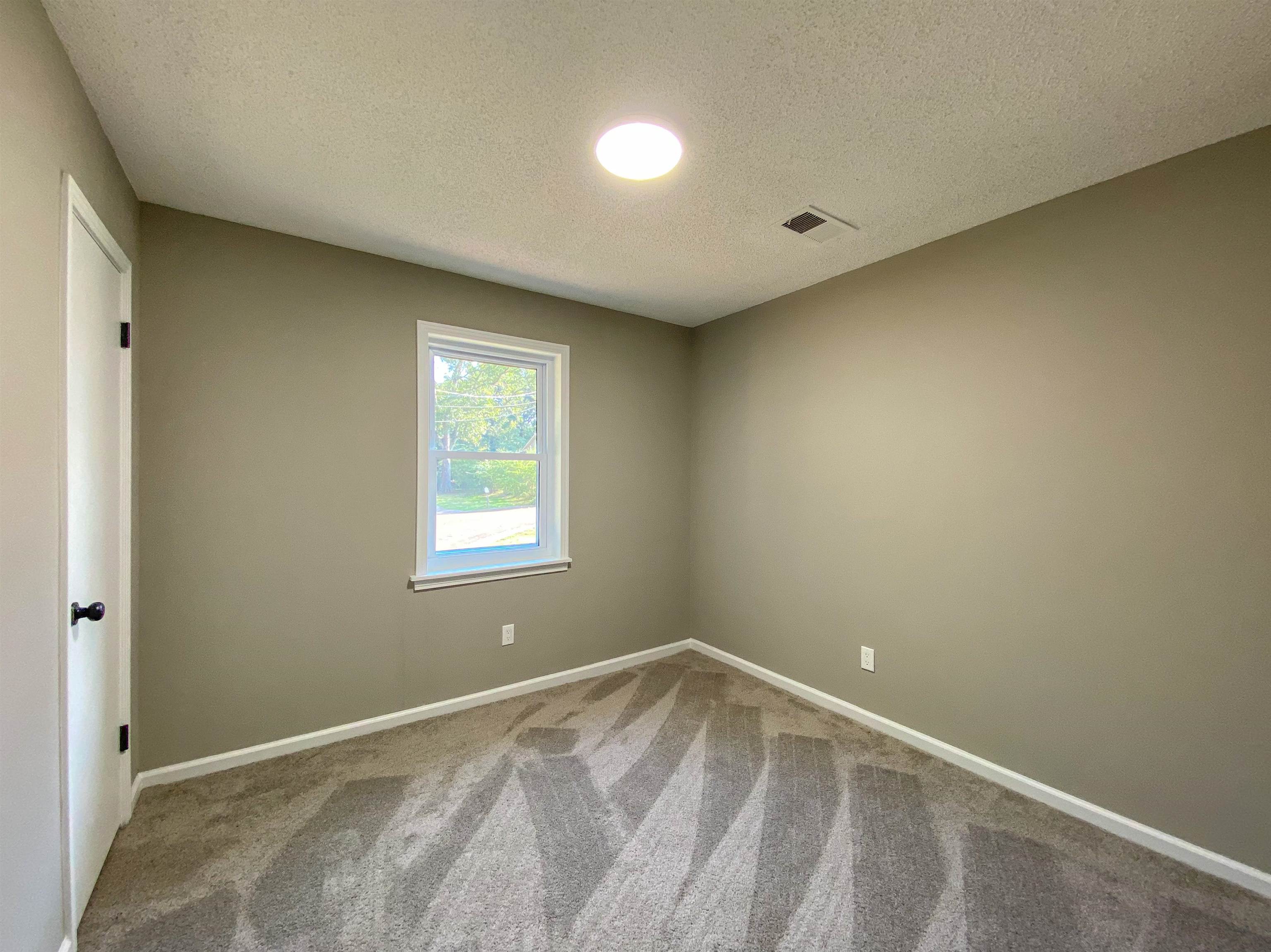 Spare room with a textured ceiling and carpet