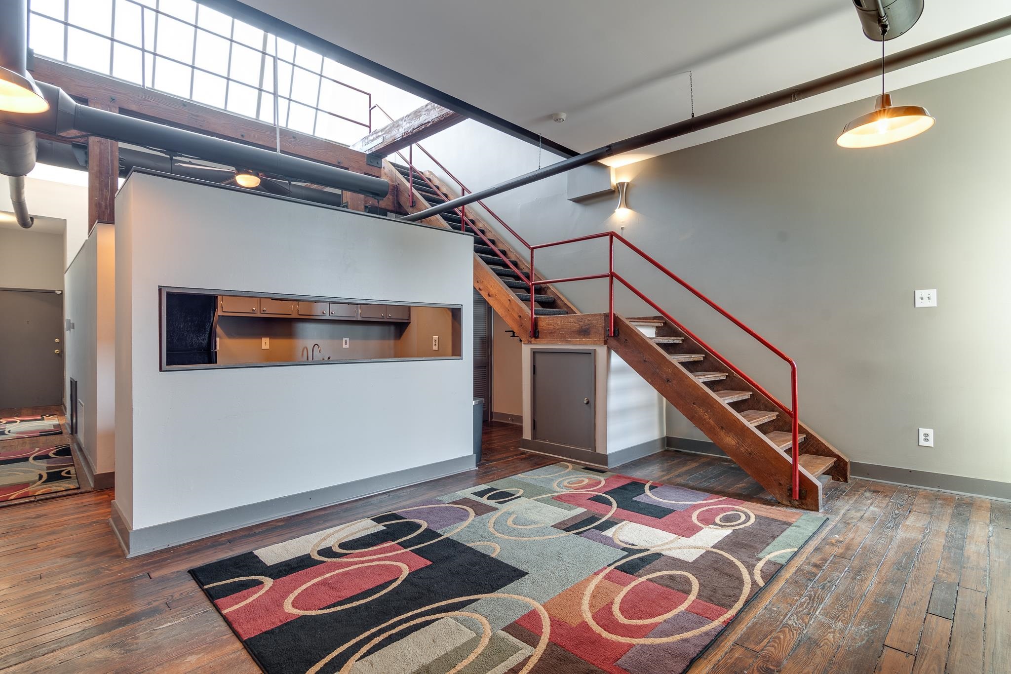 Interior space featuring a high ceiling and dark hardwood / wood-style flooring