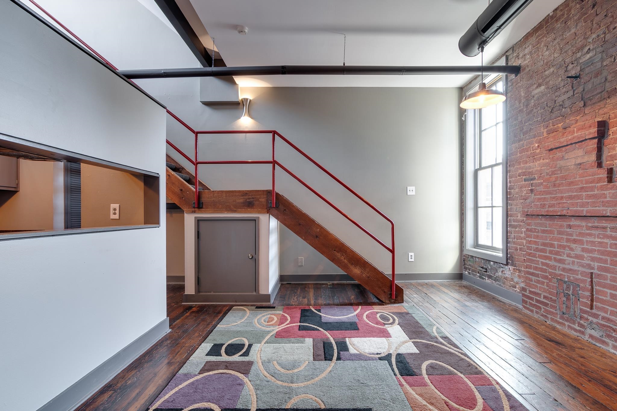 Foyer entrance featuring brick wall, dark hardwood / wood-style flooring, and a high ceiling