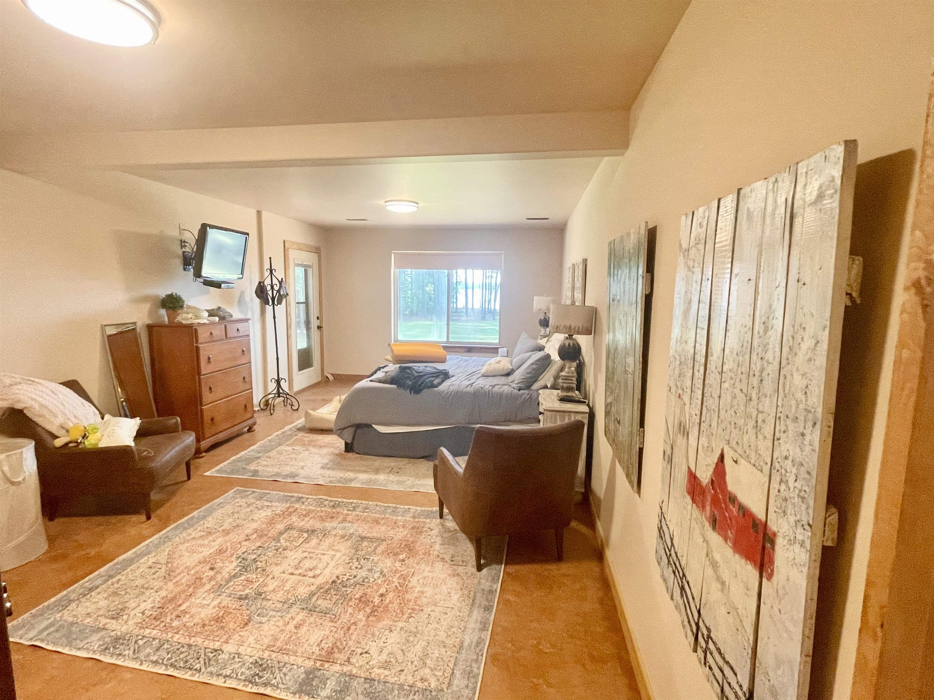 Carpeted bedroom with lofted ceiling with beams