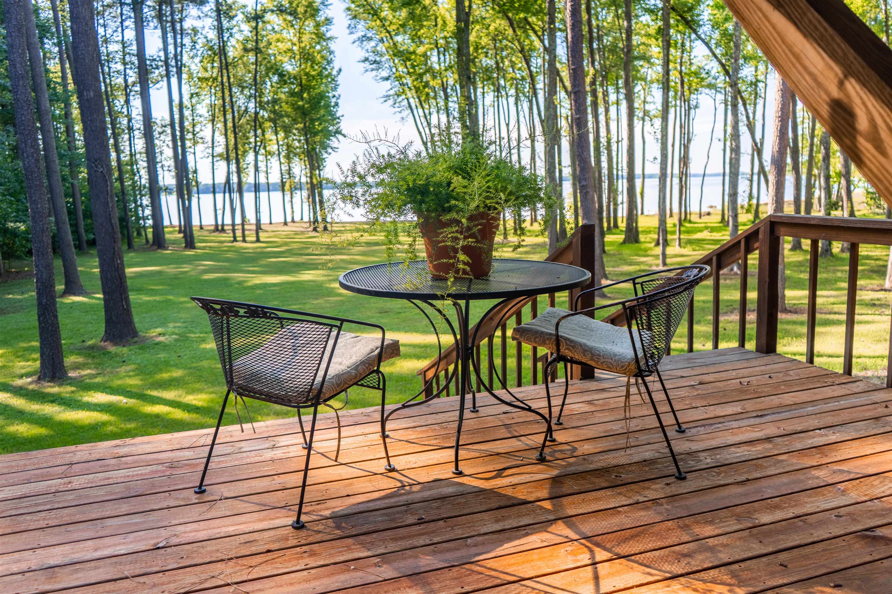 Deck with a water view and a yard