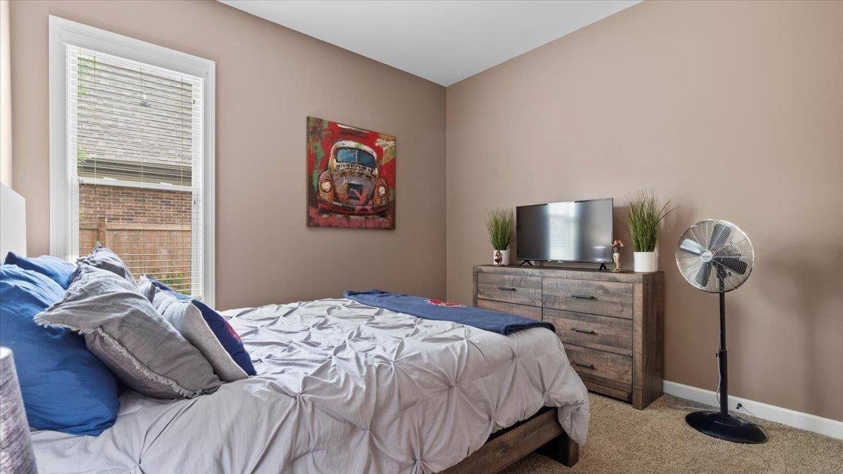 Bedroom featuring carpet floors and multiple windows