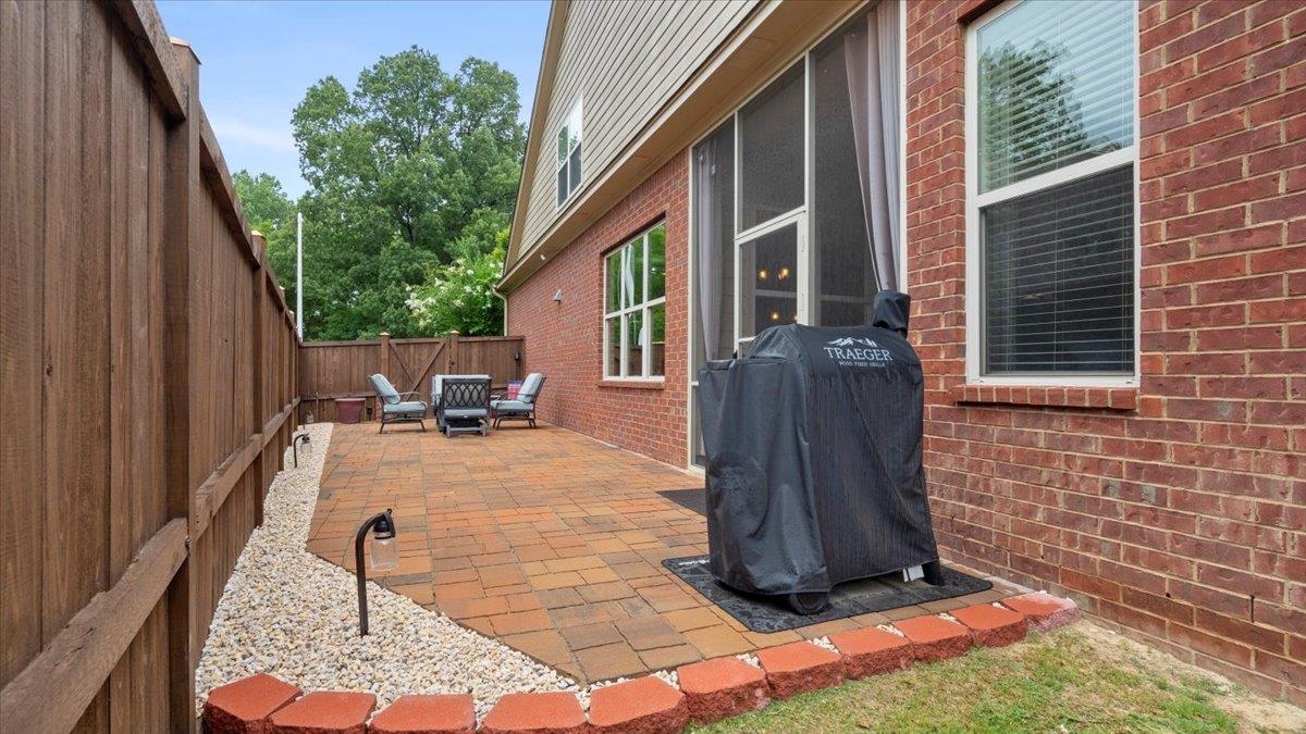 View of patio with a grill