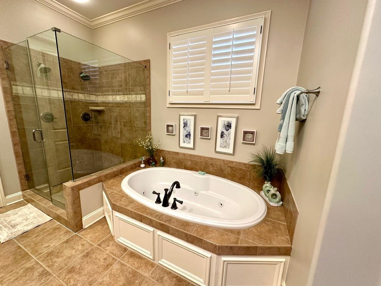 Bathroom featuring plus walk in shower, crown molding, and tile patterned flooring