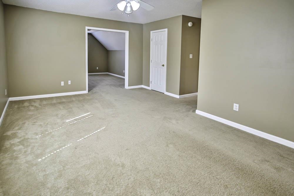 Unfurnished room with vaulted ceiling, carpet flooring, and ceiling fan