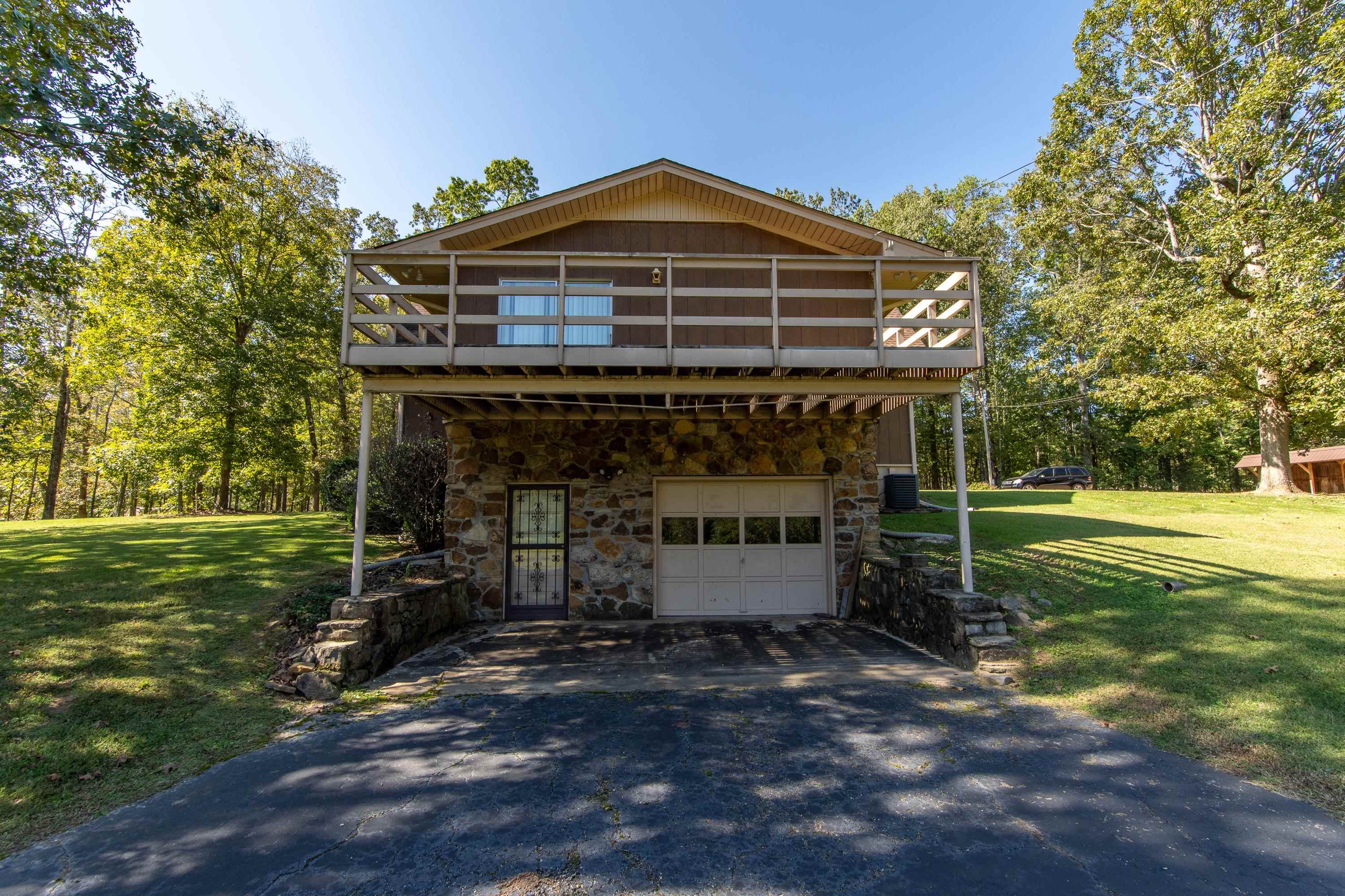 View of front of property featuring a garage, a front yard, and central AC unit