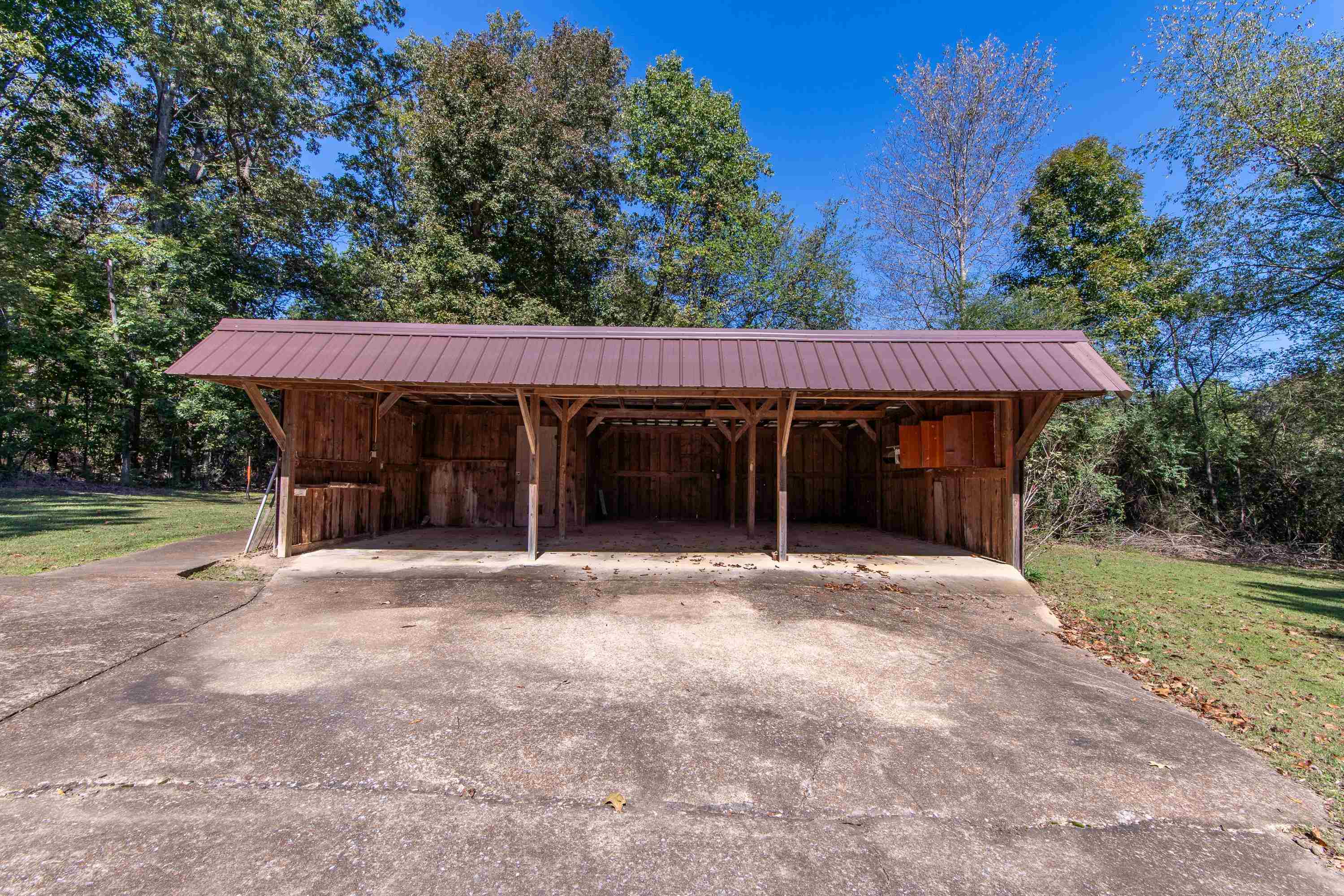 Exterior space featuring a carport and a lawn