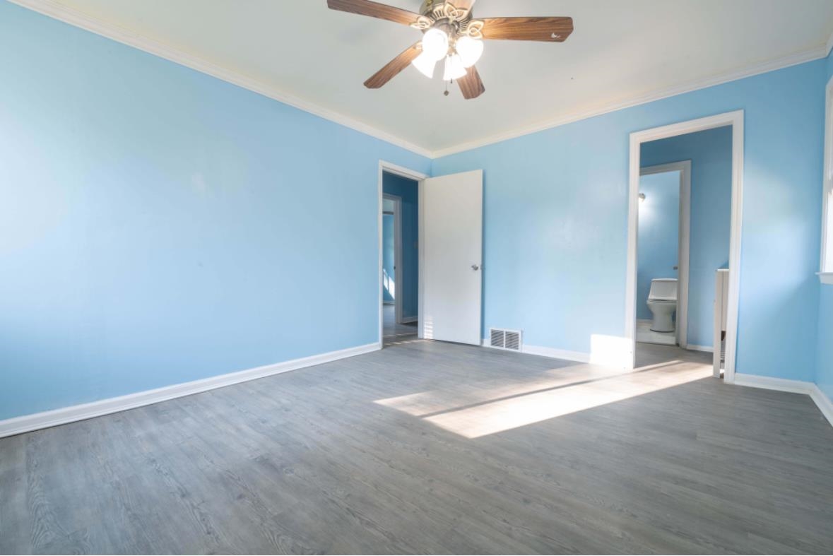 Unfurnished room featuring ceiling fan, dark hardwood / wood-style floors, and crown molding