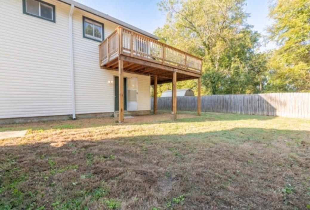 Back of house featuring a wooden deck and a yard