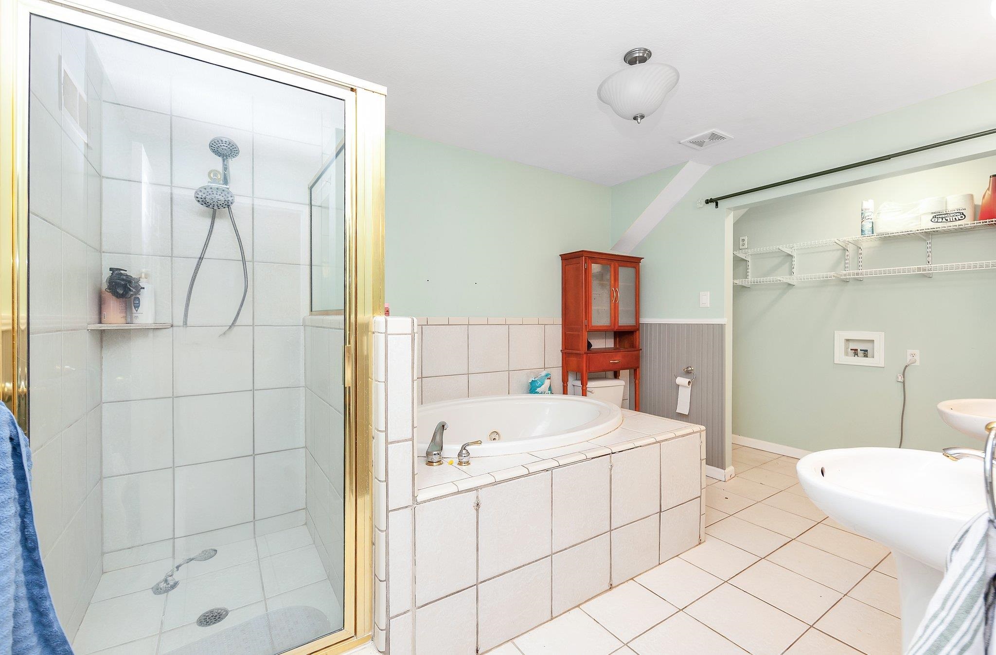 Bathroom with tile patterned flooring and independent shower and bath