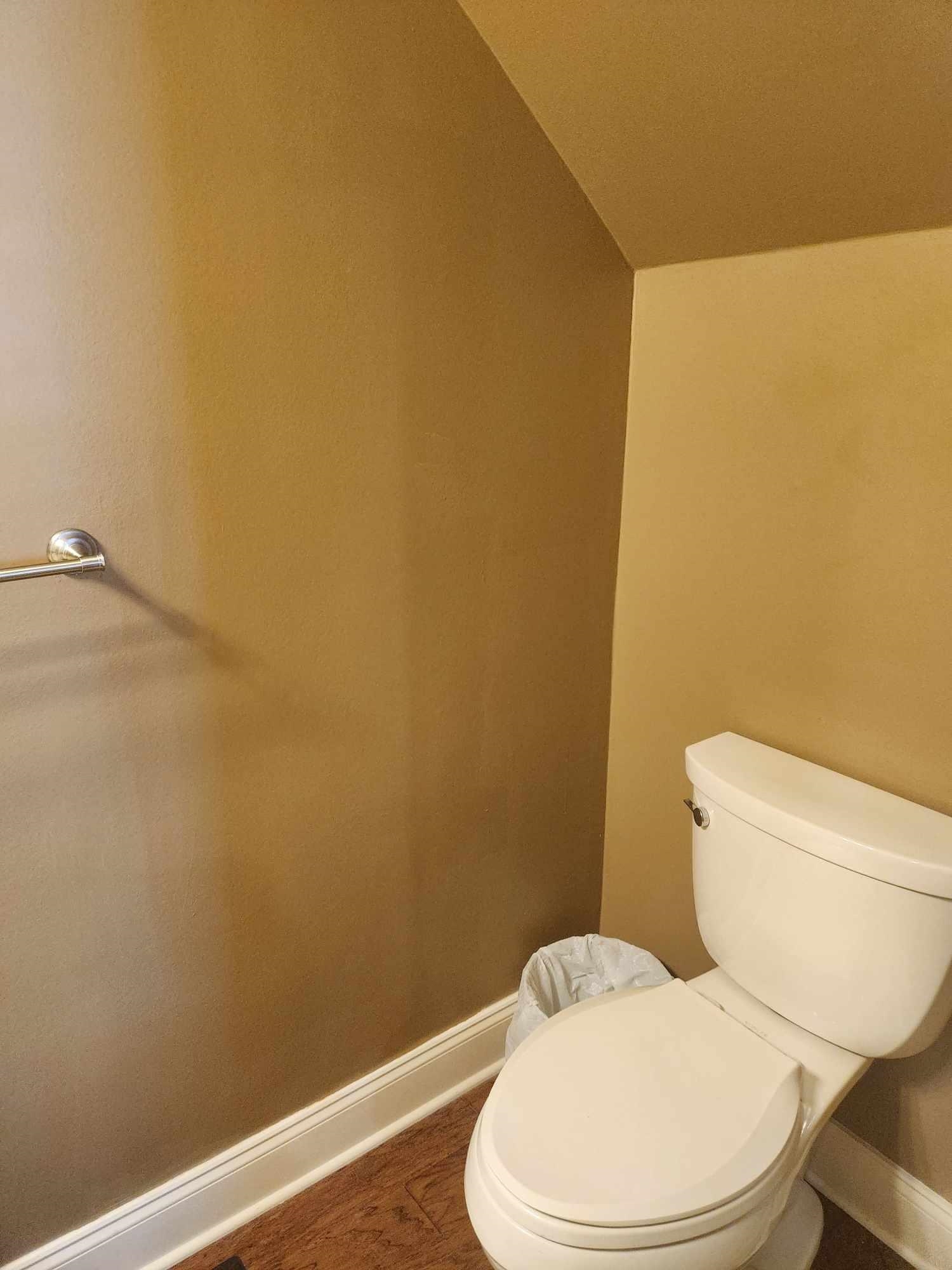 Bathroom with toilet, vaulted ceiling, and hardwood / wood-style flooring