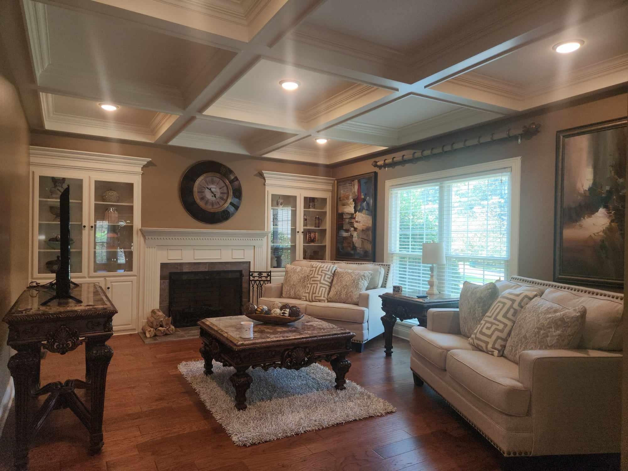 Living room featuring ornamental molding, coffered ceiling, and dark hardwood / wood-style flooring