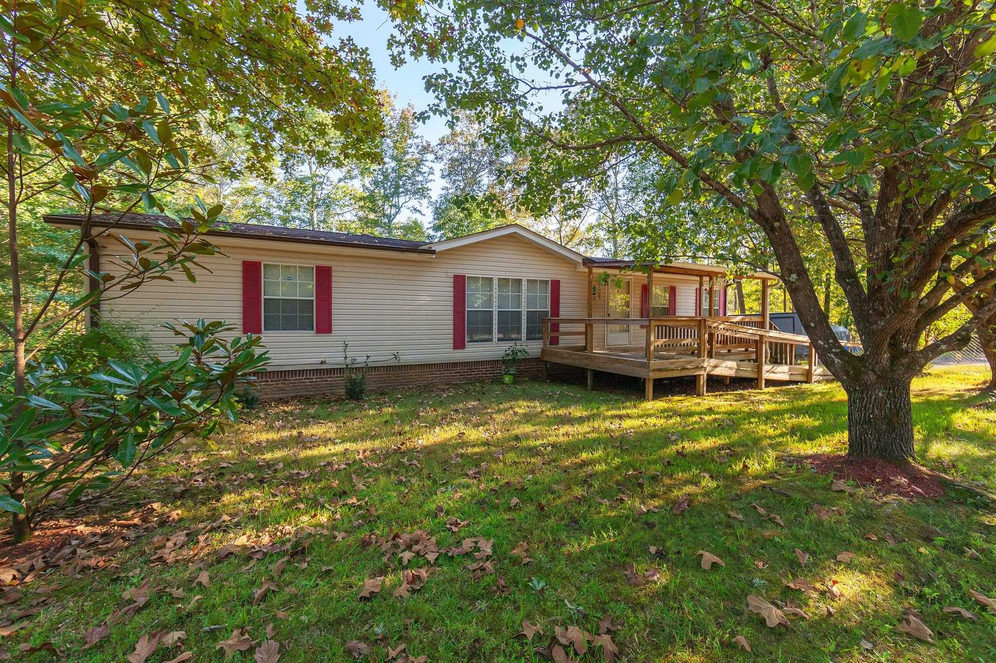 Rear view of house featuring a deck and a lawn