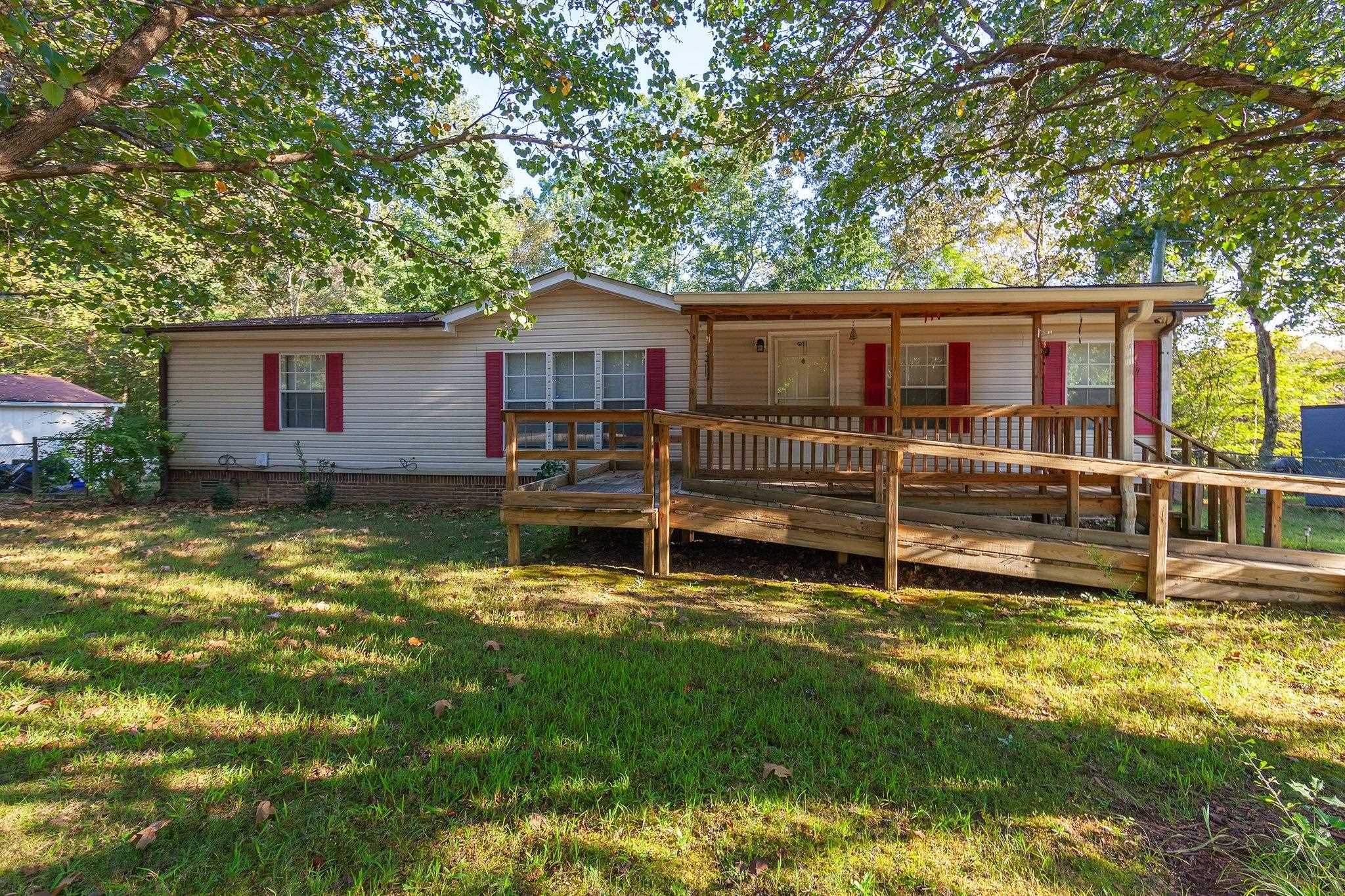 Back of house featuring a yard and a wooden deck