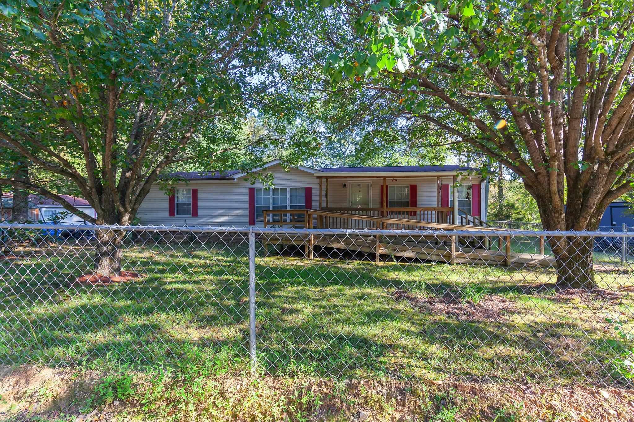 View of front of property with a deck and a front lawn