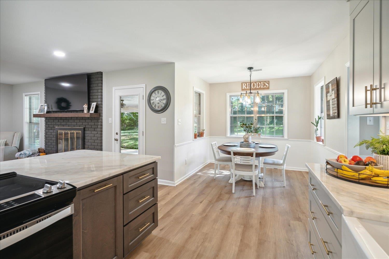 Kitchen with electric stove, a brick fireplace, and a wealth of natural light