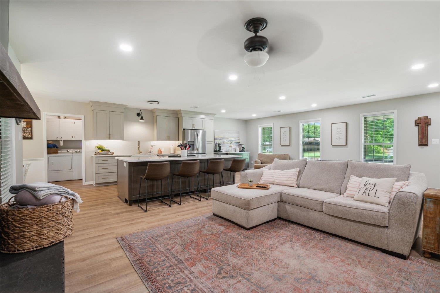 Living room with ceiling fan and light hardwood / wood-style flooring