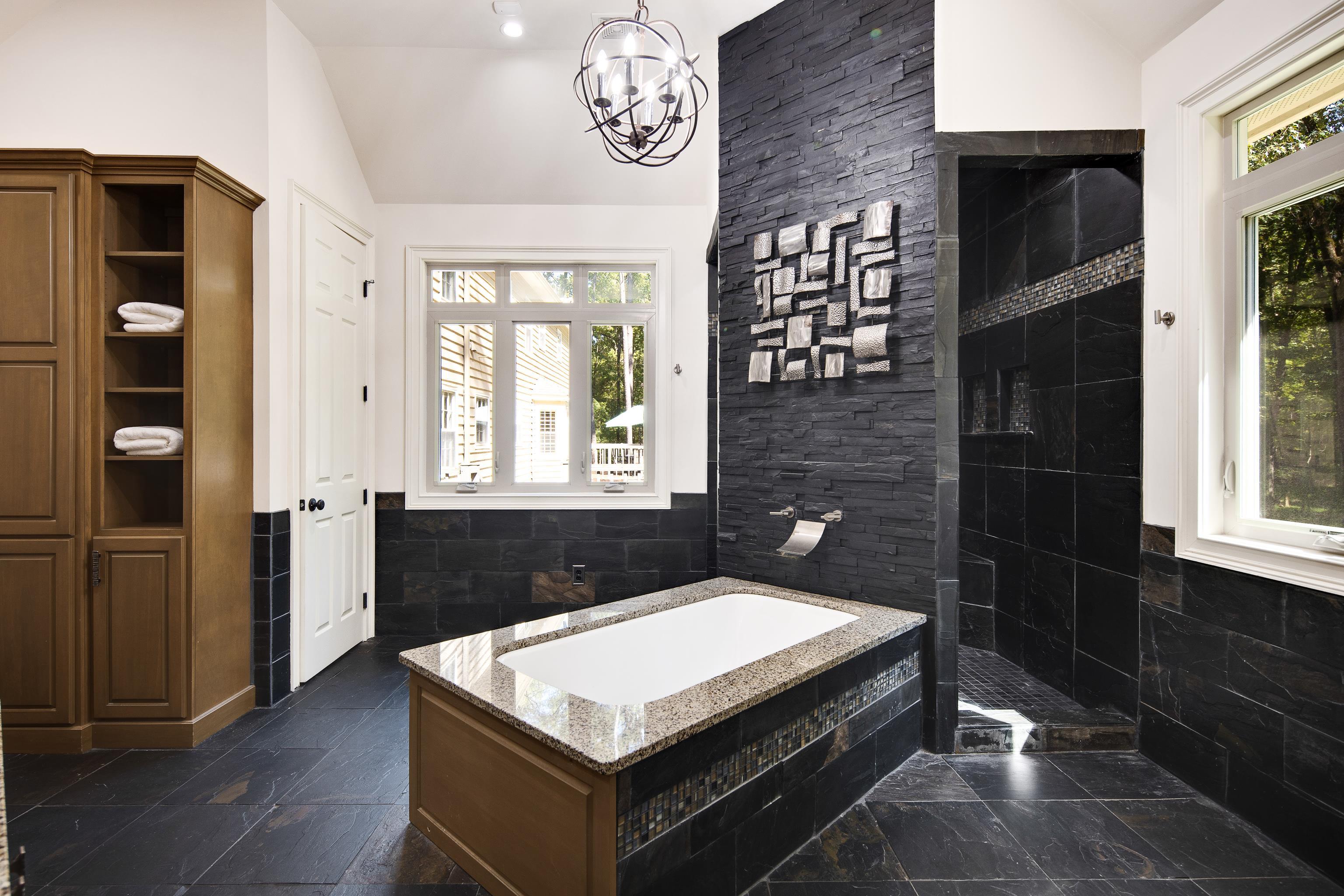 Bathroom featuring lofted ceiling, plus walk in shower, and tile walls