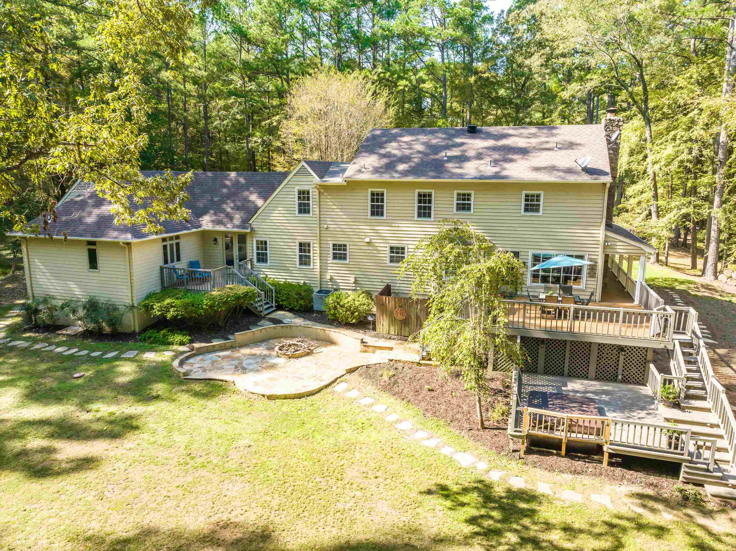 Rear view of house with a wooden deck and a yard