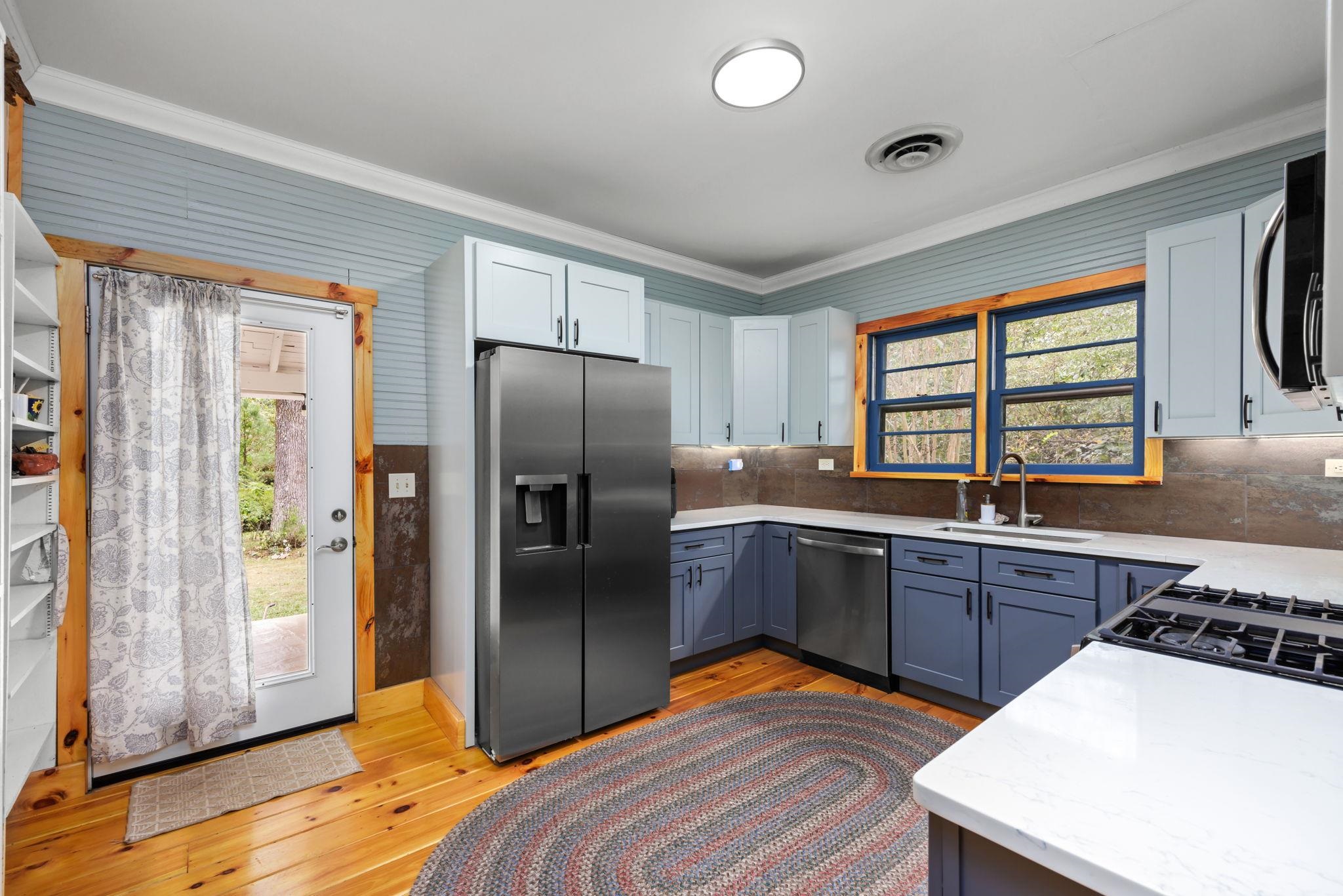 Kitchen featuring appliances with stainless steel finishes, light wood-type flooring, sink, and crown molding