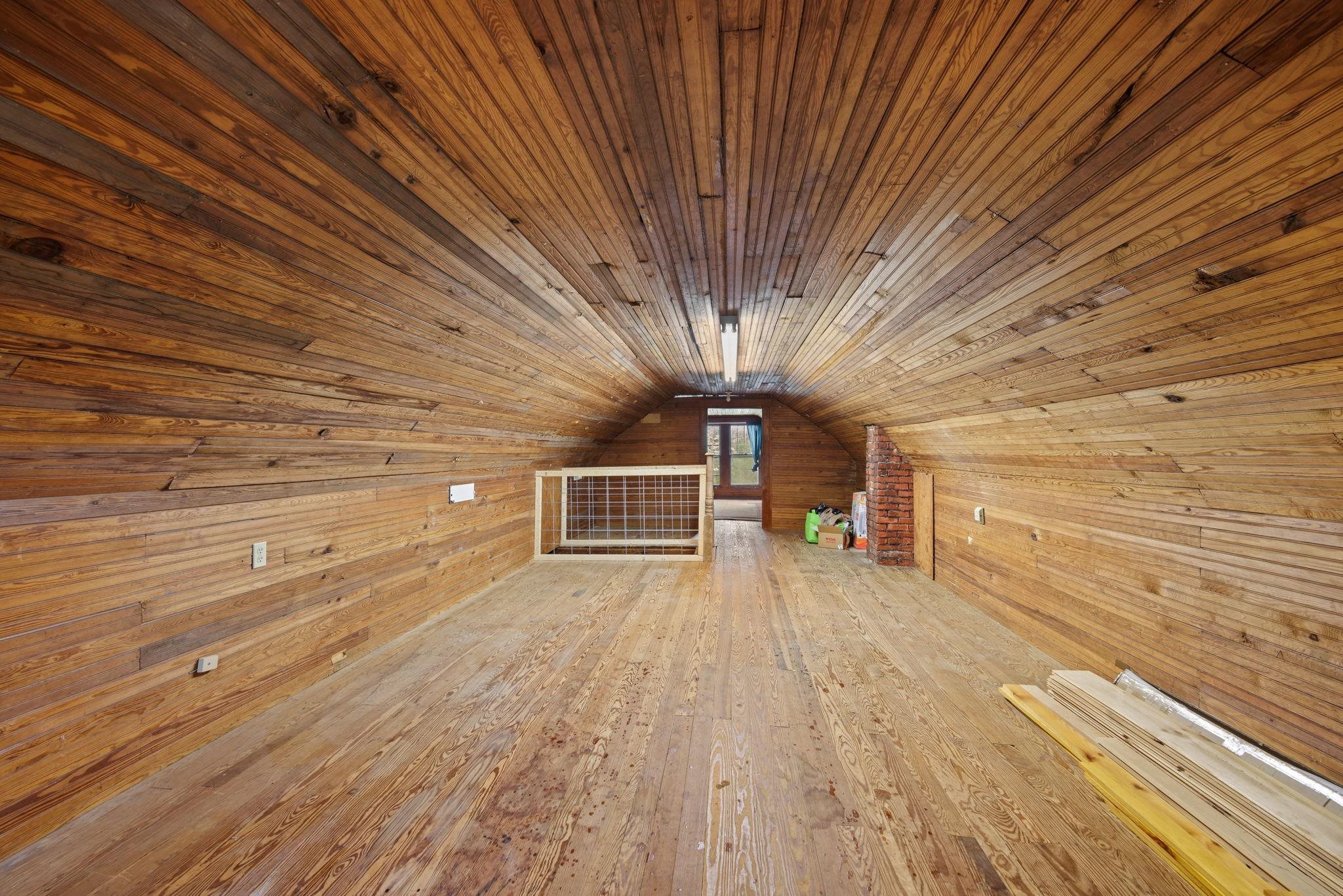 Additional living space with lofted ceiling, wood-type flooring, wooden ceiling, and wooden walls