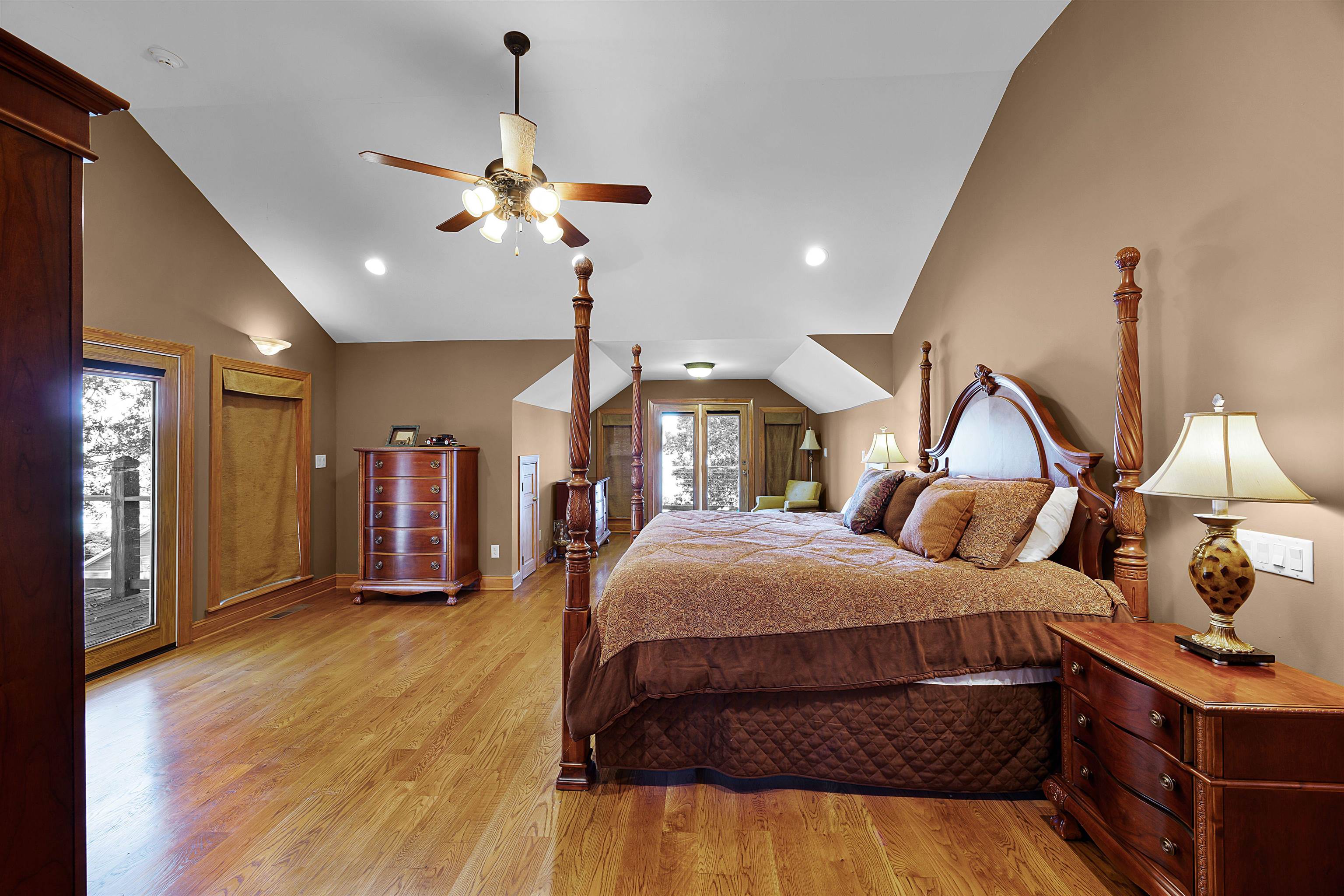 Bedroom featuring ceiling fan, lofted ceiling, light hardwood / wood-style floors, and access to outside