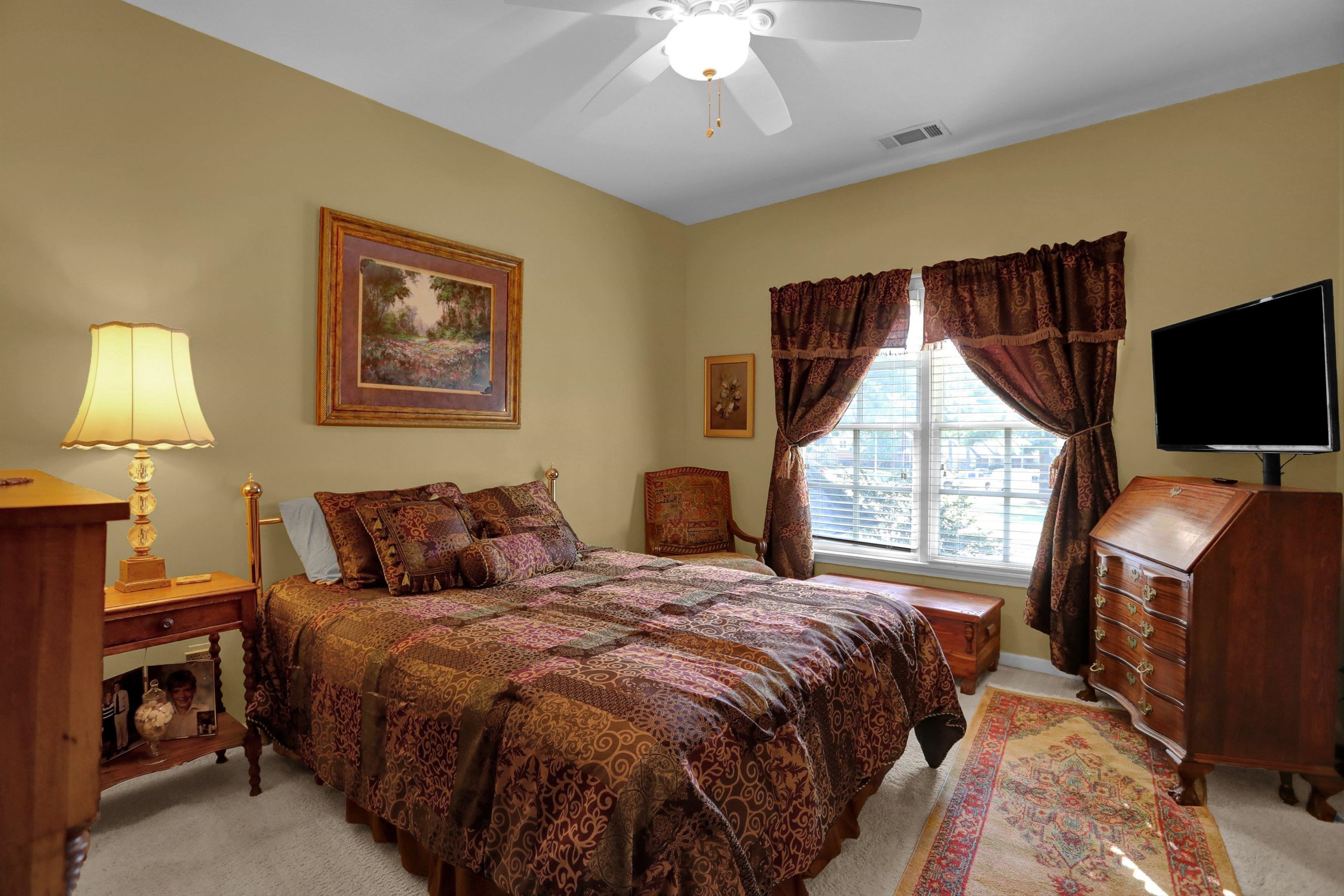 Carpeted bedroom featuring ceiling fan