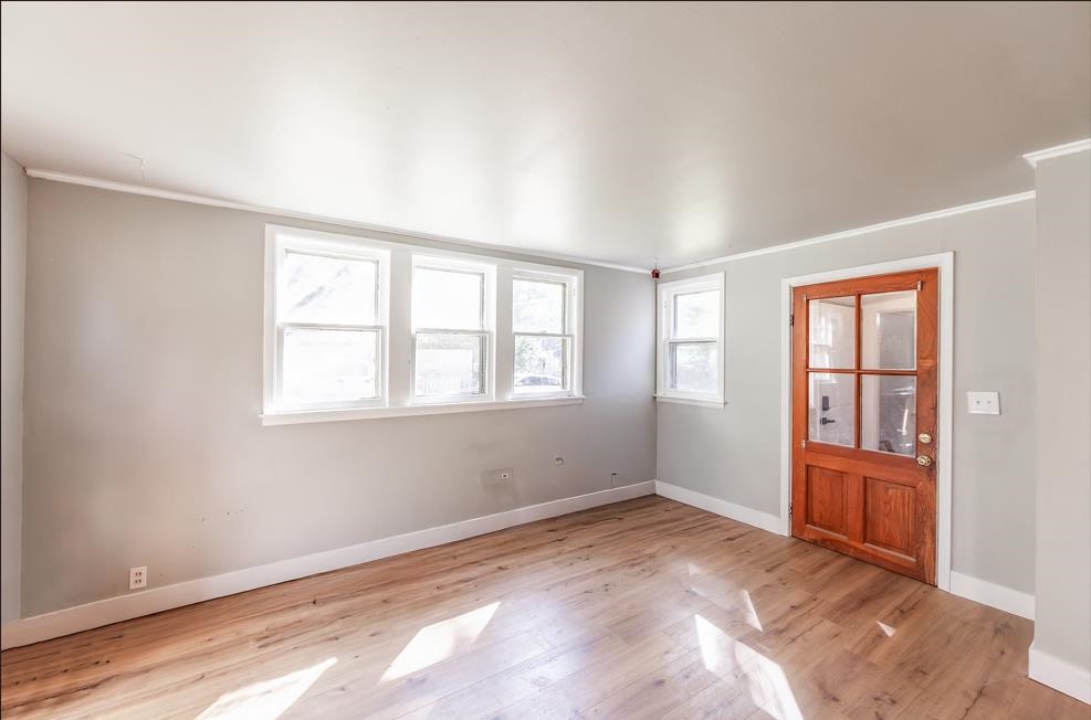 Unfurnished room featuring crown molding and light hardwood / wood-style flooring