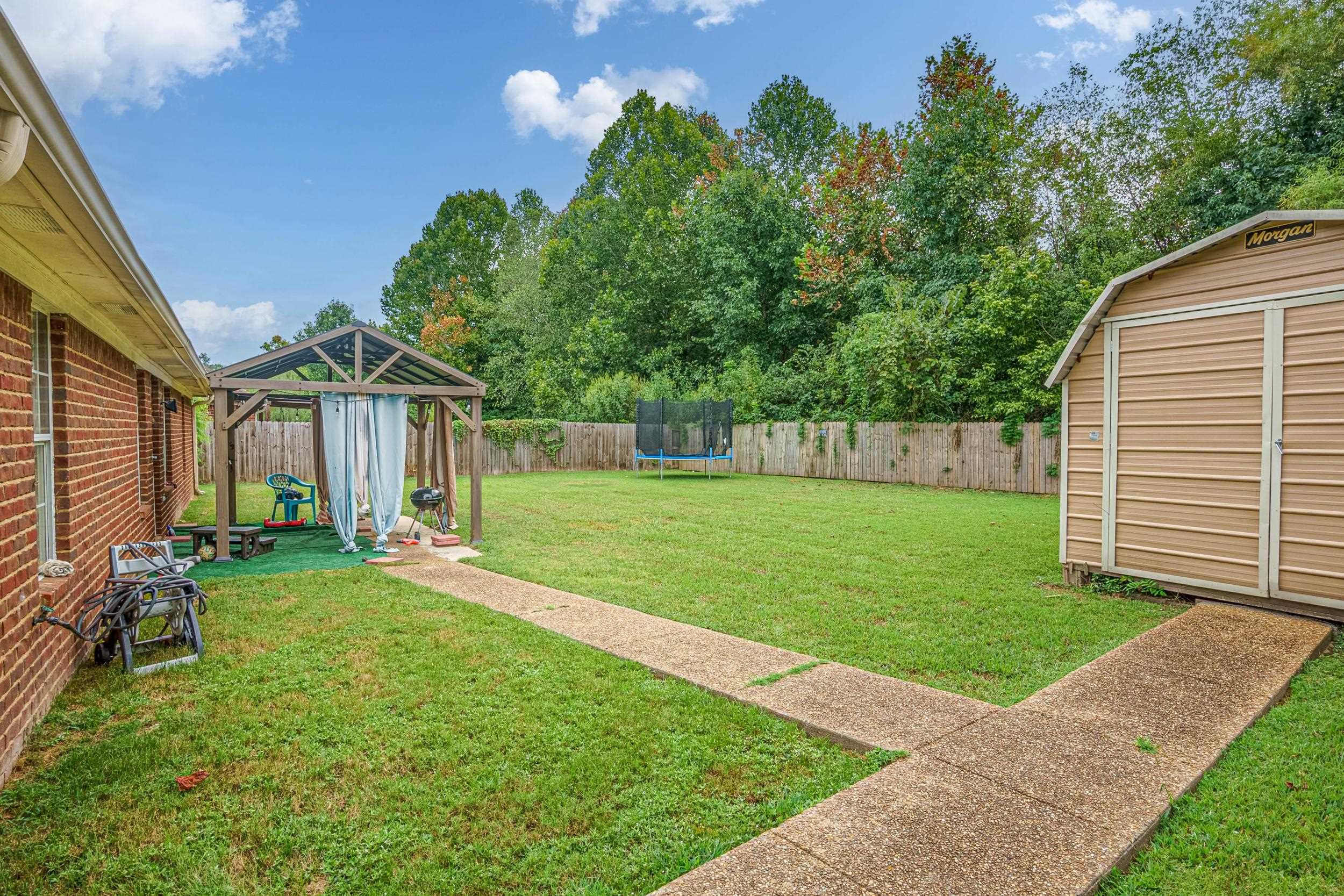 View of yard with a storage shed and a trampoline