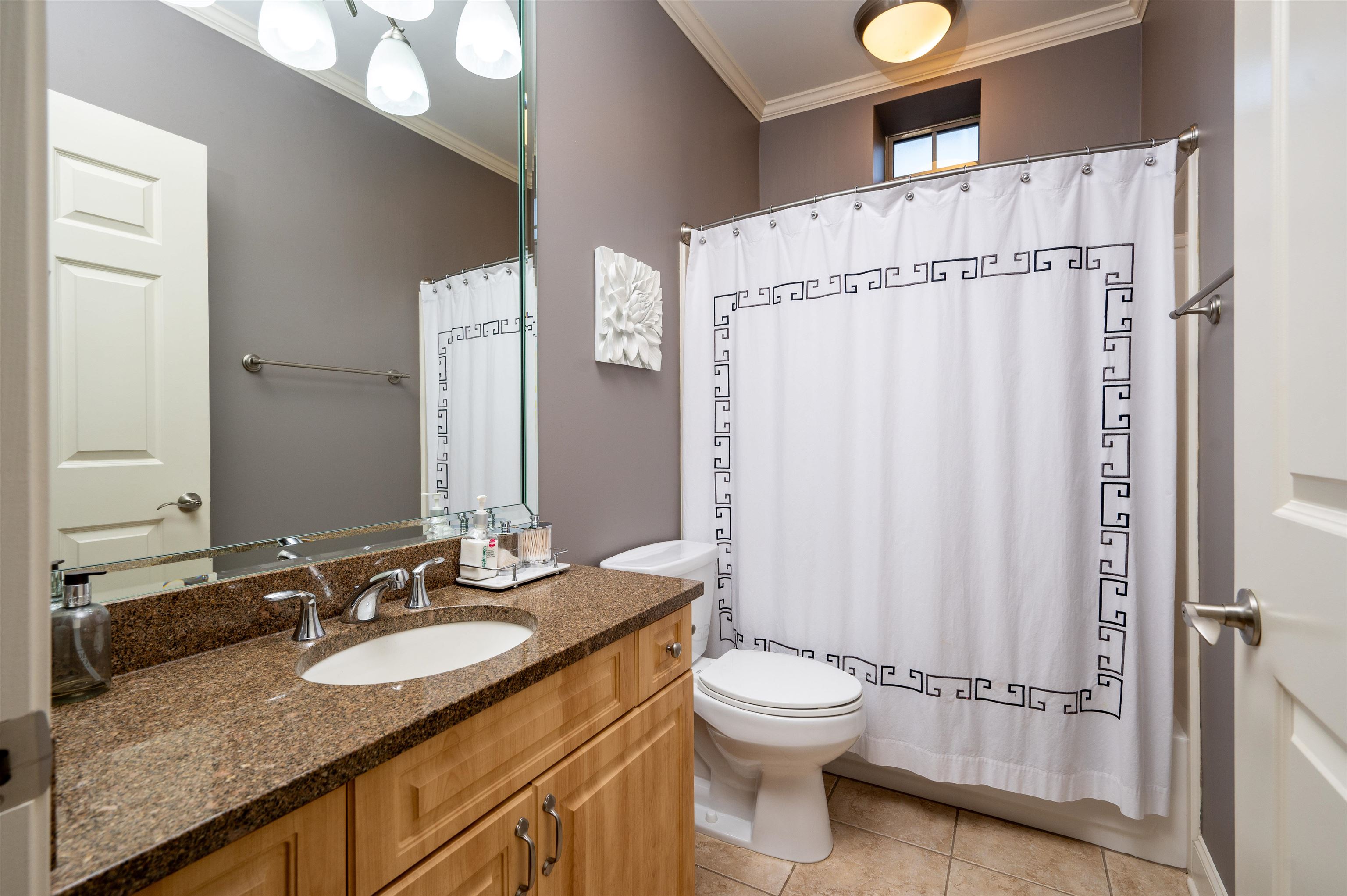 Full bathroom with ornamental molding, vanity, toilet, and tile patterned floors