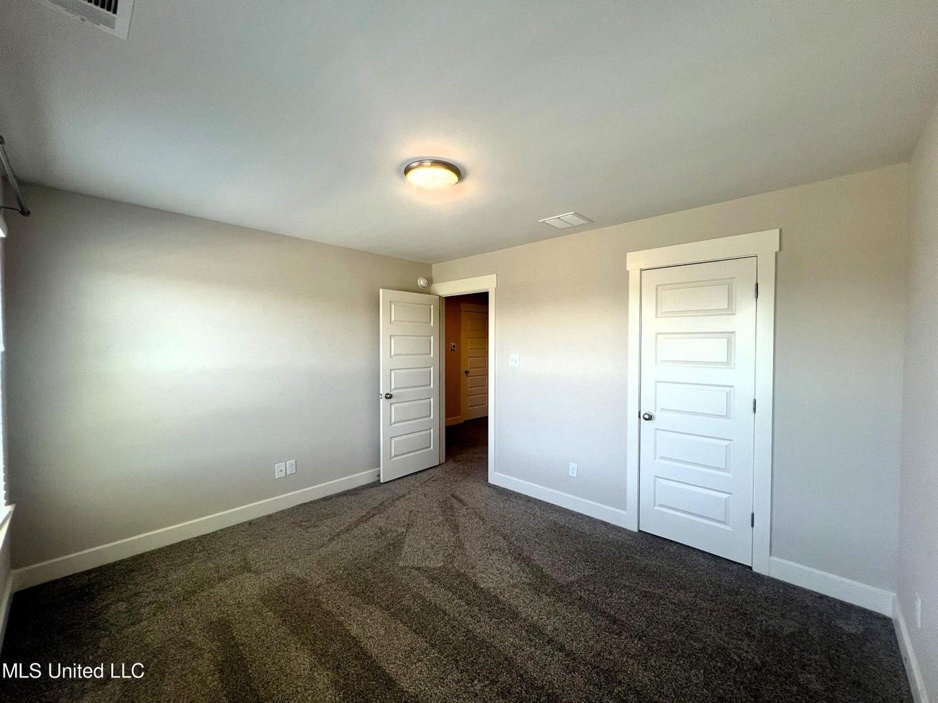 Unfurnished bedroom with dark carpet and a closet