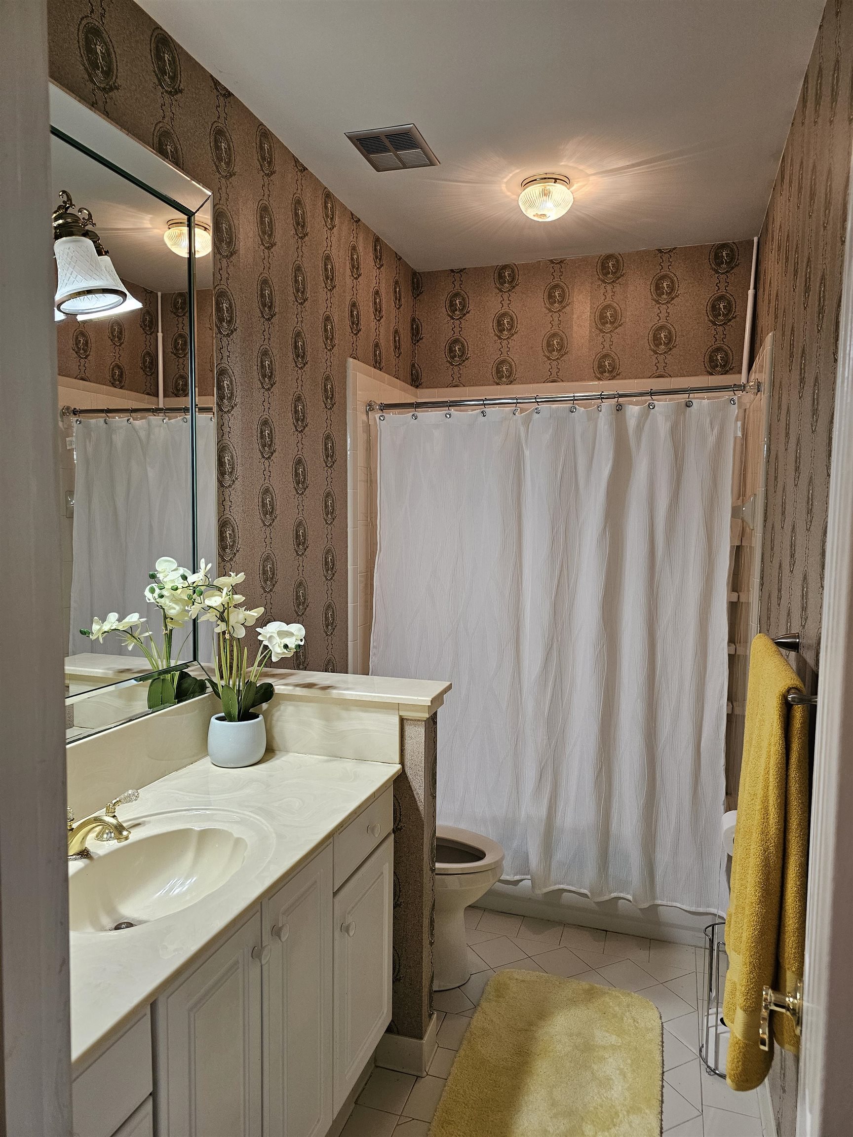 Full bathroom with vanity, tile patterned floors, toilet, and shower / tub combo with curtain