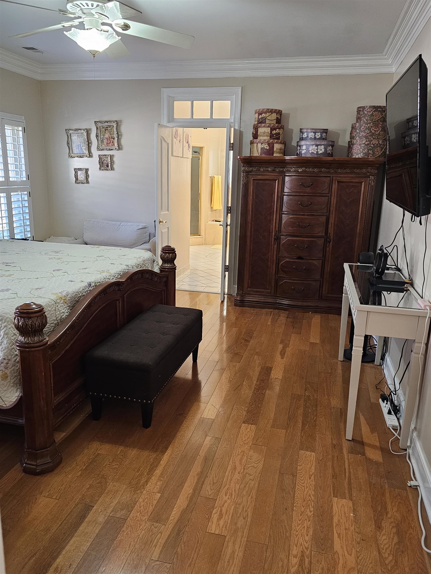 Bedroom featuring crown molding, hardwood / wood-style flooring, and ceiling fan