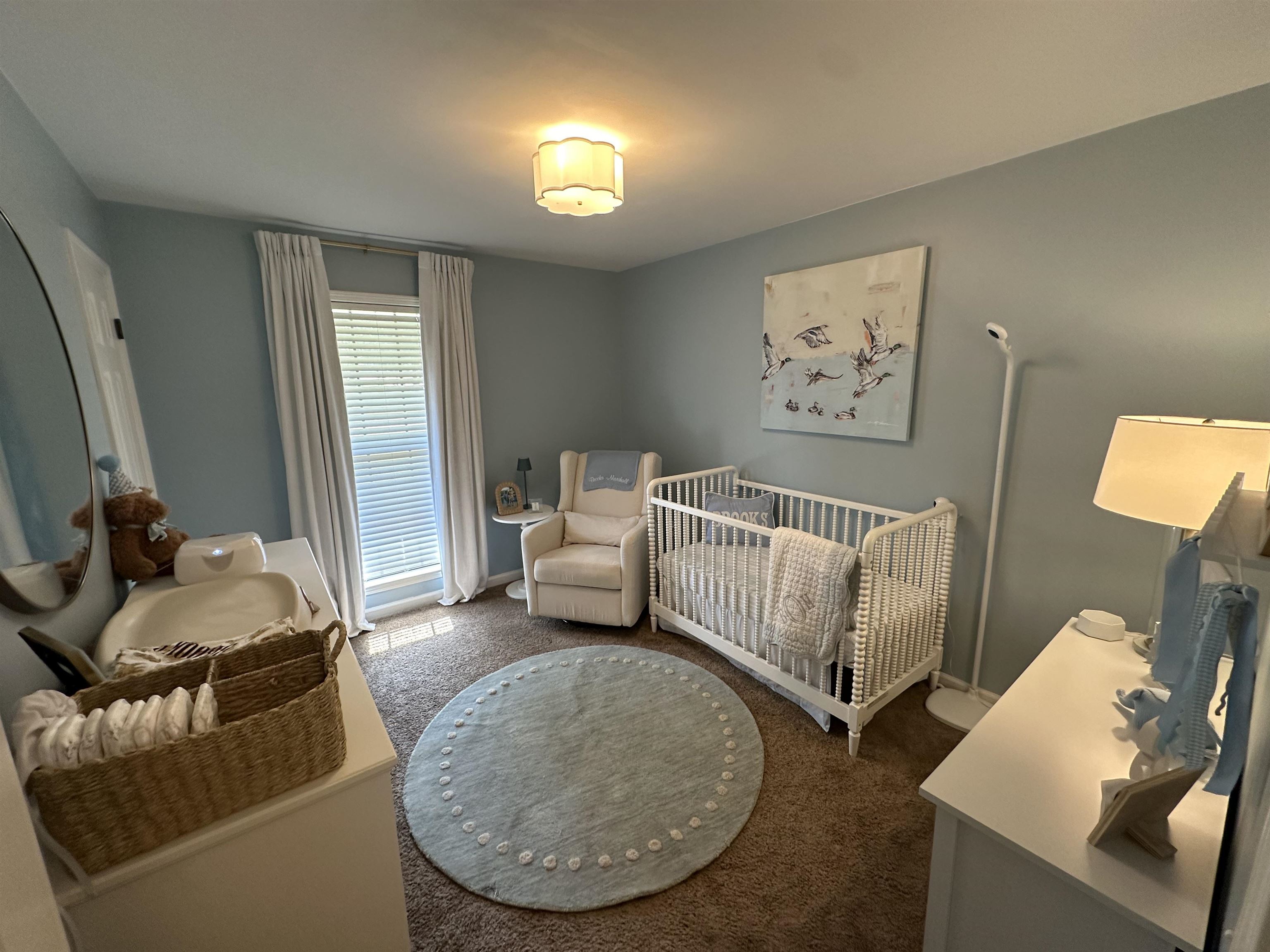 Bedroom featuring a nursery area and dark colored carpet