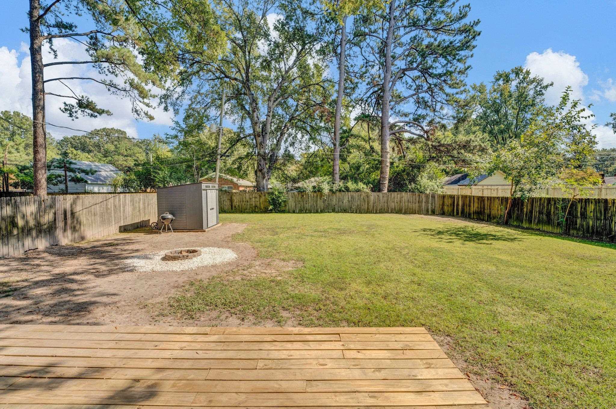 View of yard with a wooden deck and a storage shed