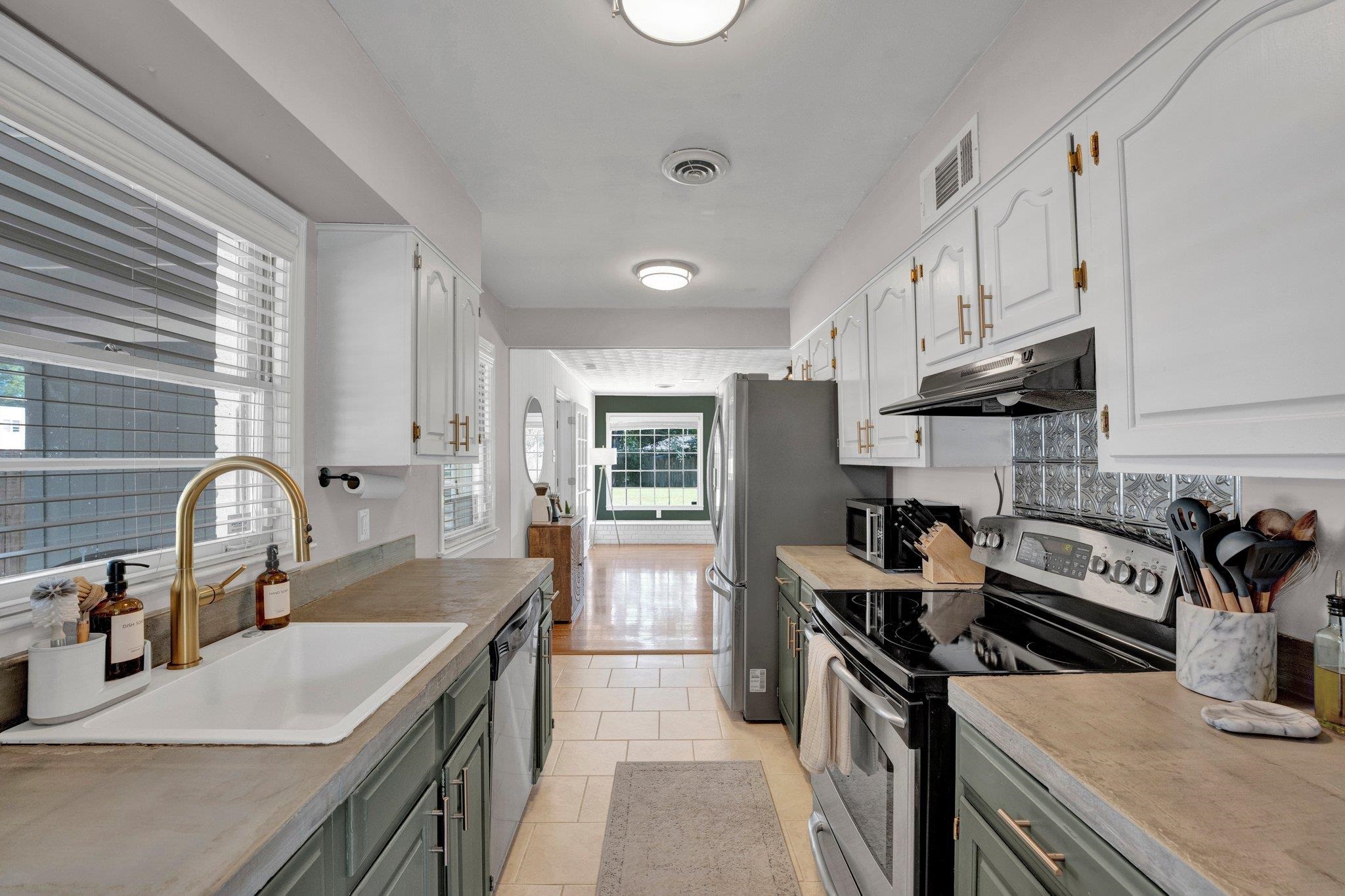 Kitchen featuring light tile patterned flooring, gray cabinets, sink, white cabinets, and appliances with stainless steel finishes