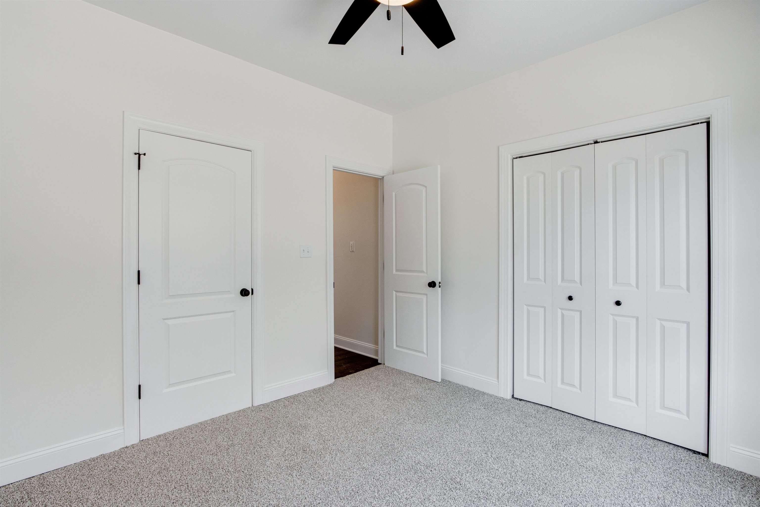 Unfurnished bedroom with carpet floors, ceiling fan, and a closet