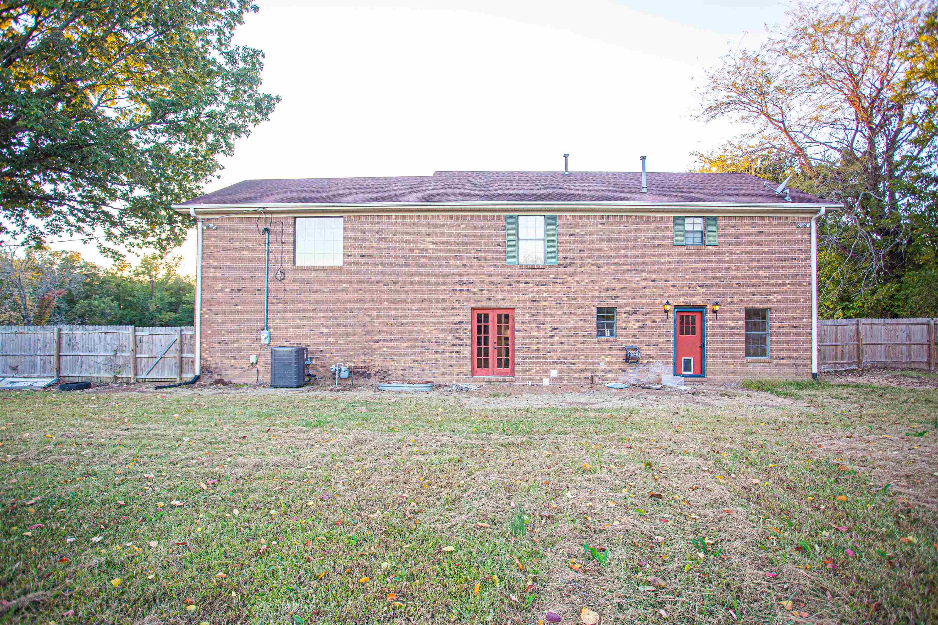 Back of house featuring a lawn and central air condition unit