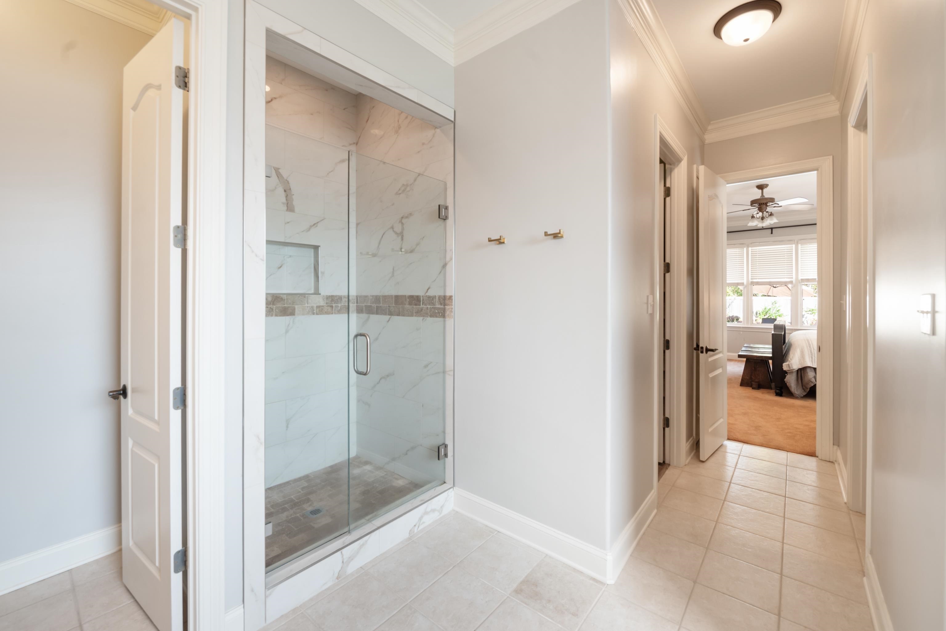 Bathroom featuring crown molding, tile patterned flooring, and a shower with door