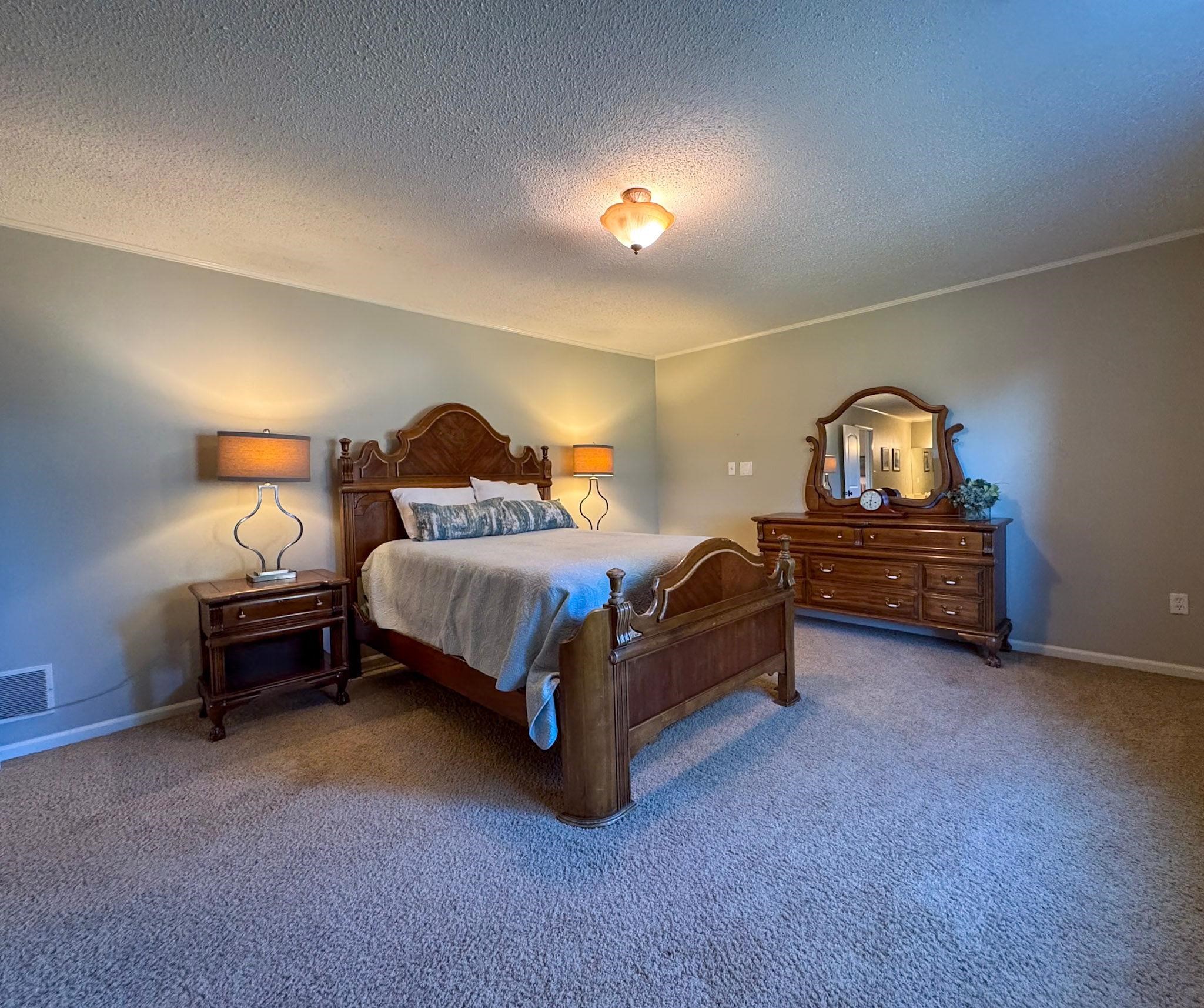 Carpeted bedroom with a textured ceiling