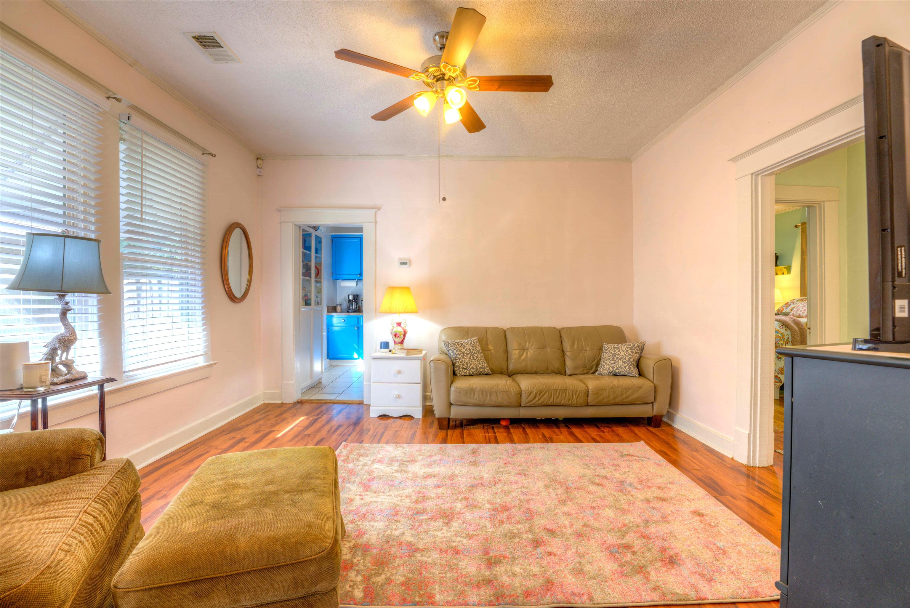 Living room with light wood-type flooring, ceiling fan, and a textured ceiling