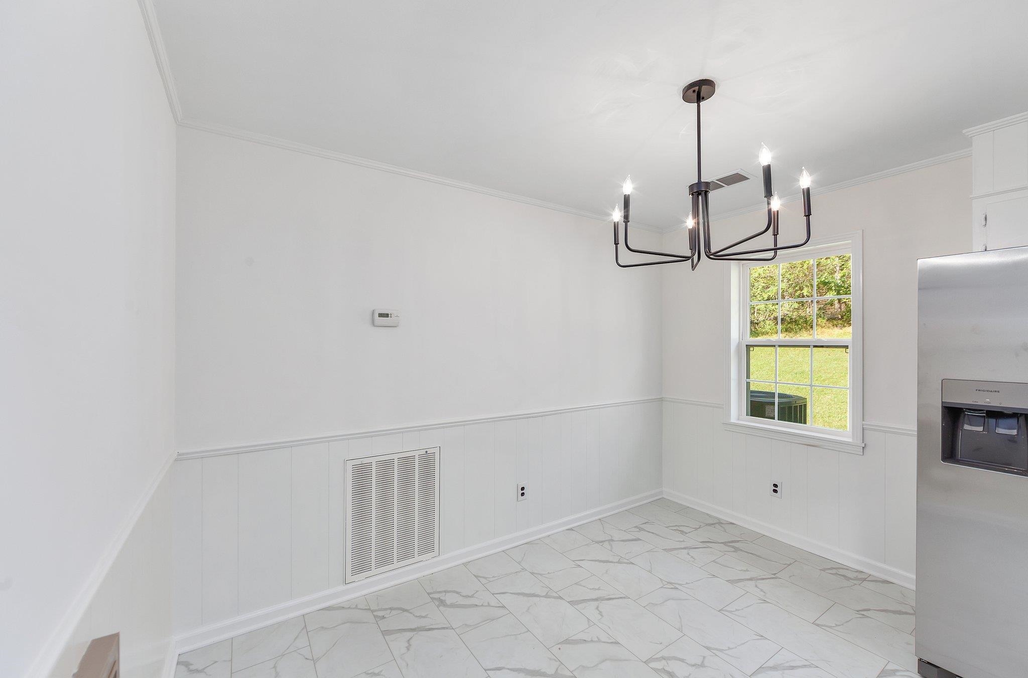 Unfurnished dining area with ornamental molding and an inviting chandelier