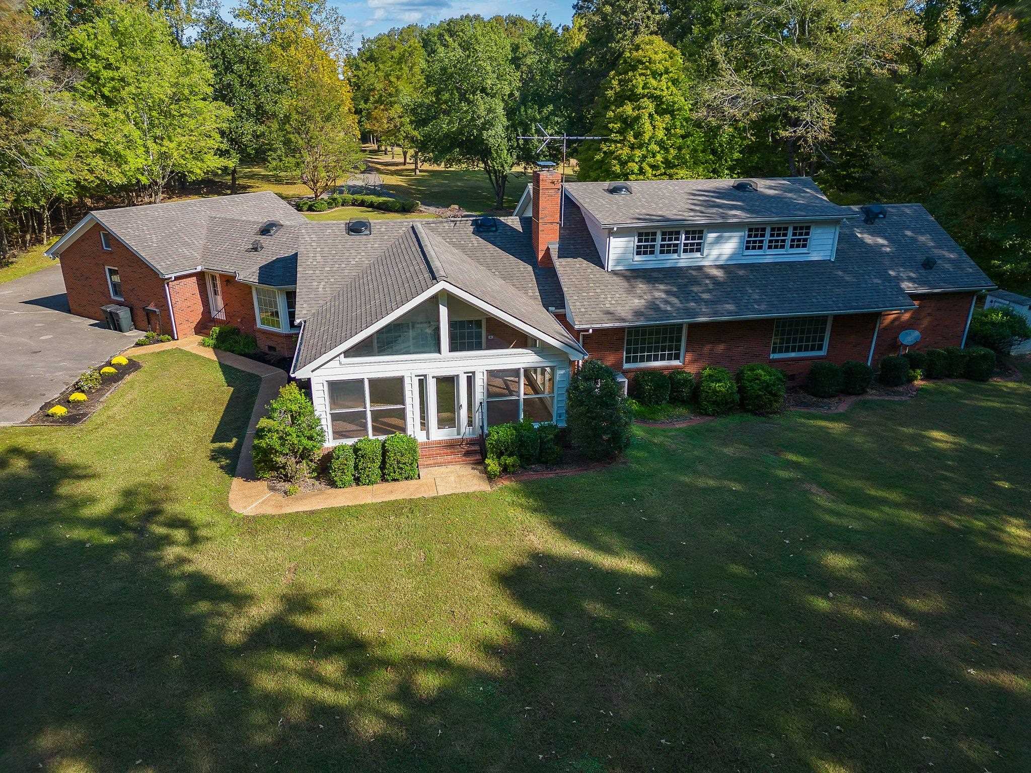 Rear view of property featuring a yard and a sunroom