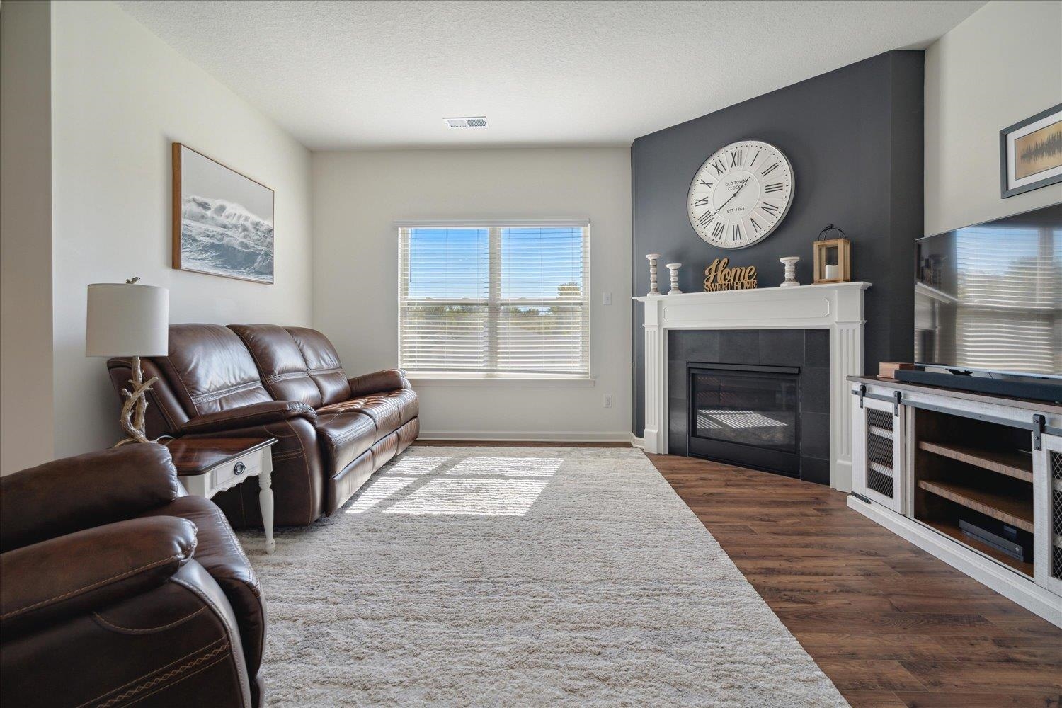 Living room featuring a textured ceiling, a tile fireplace, and dark hardwood / wood-style floors