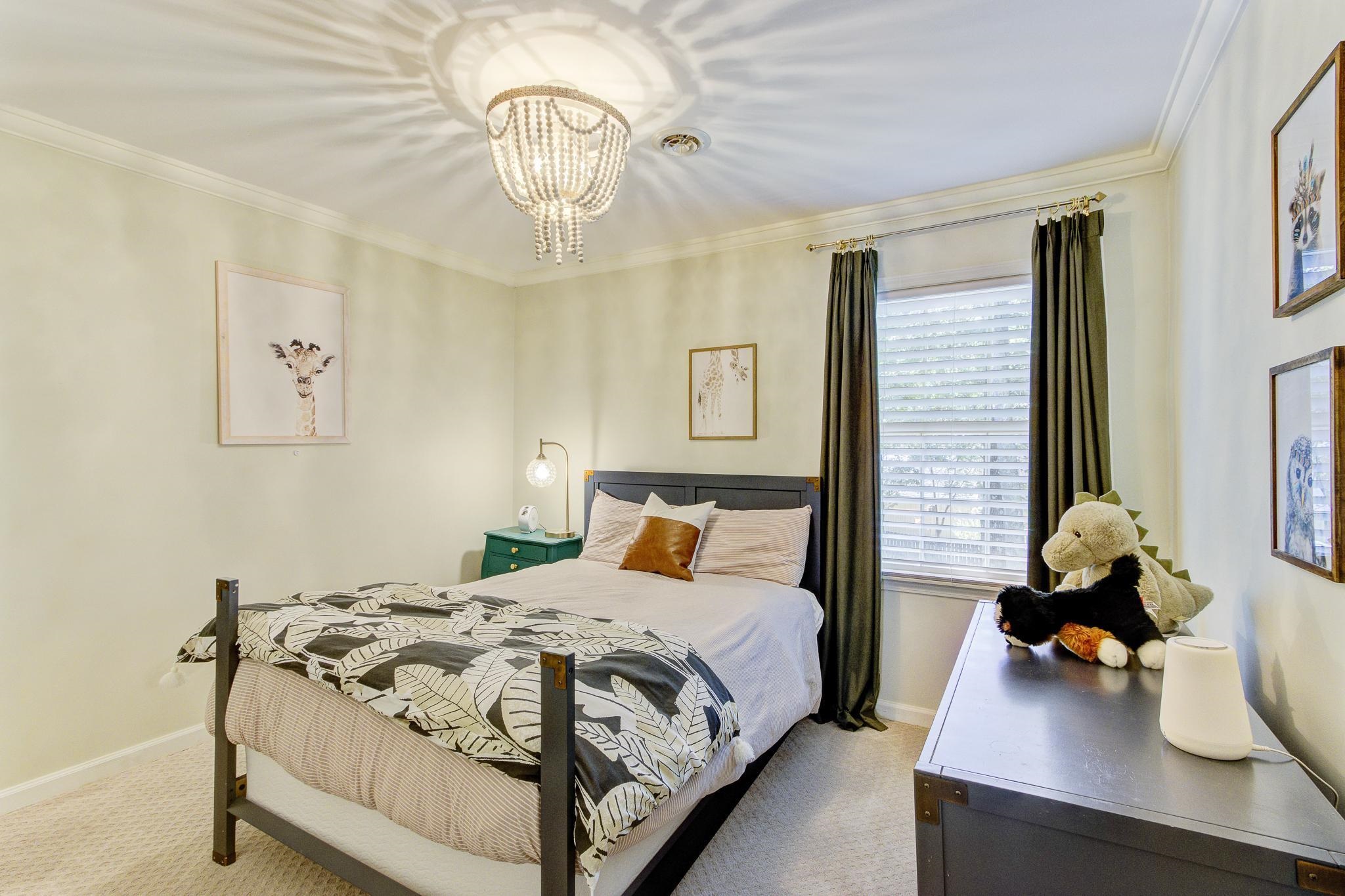 Carpeted bedroom featuring crown molding and an inviting chandelier