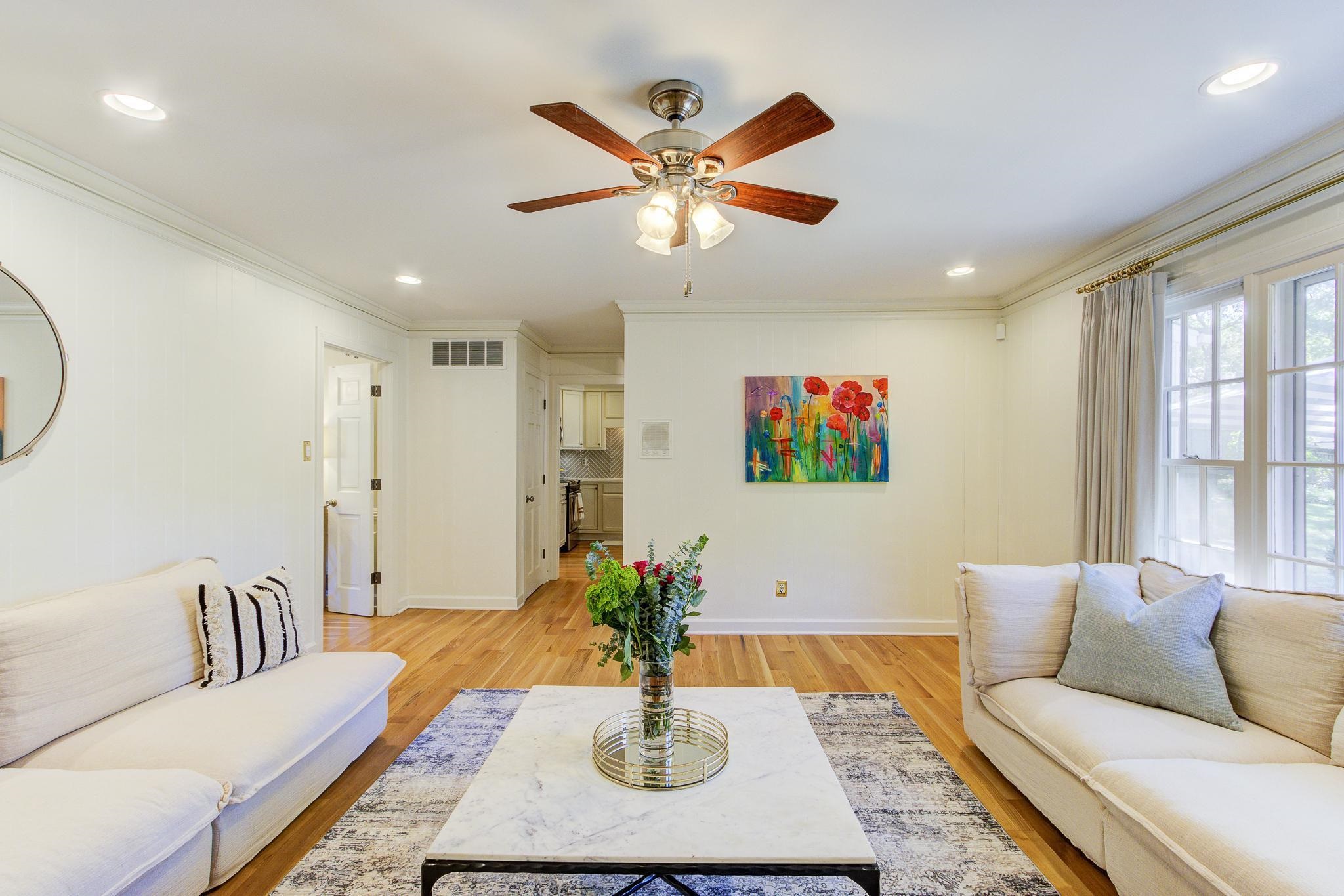 Living room featuring light hardwood / wood-style flooring, crown molding, and ceiling fan