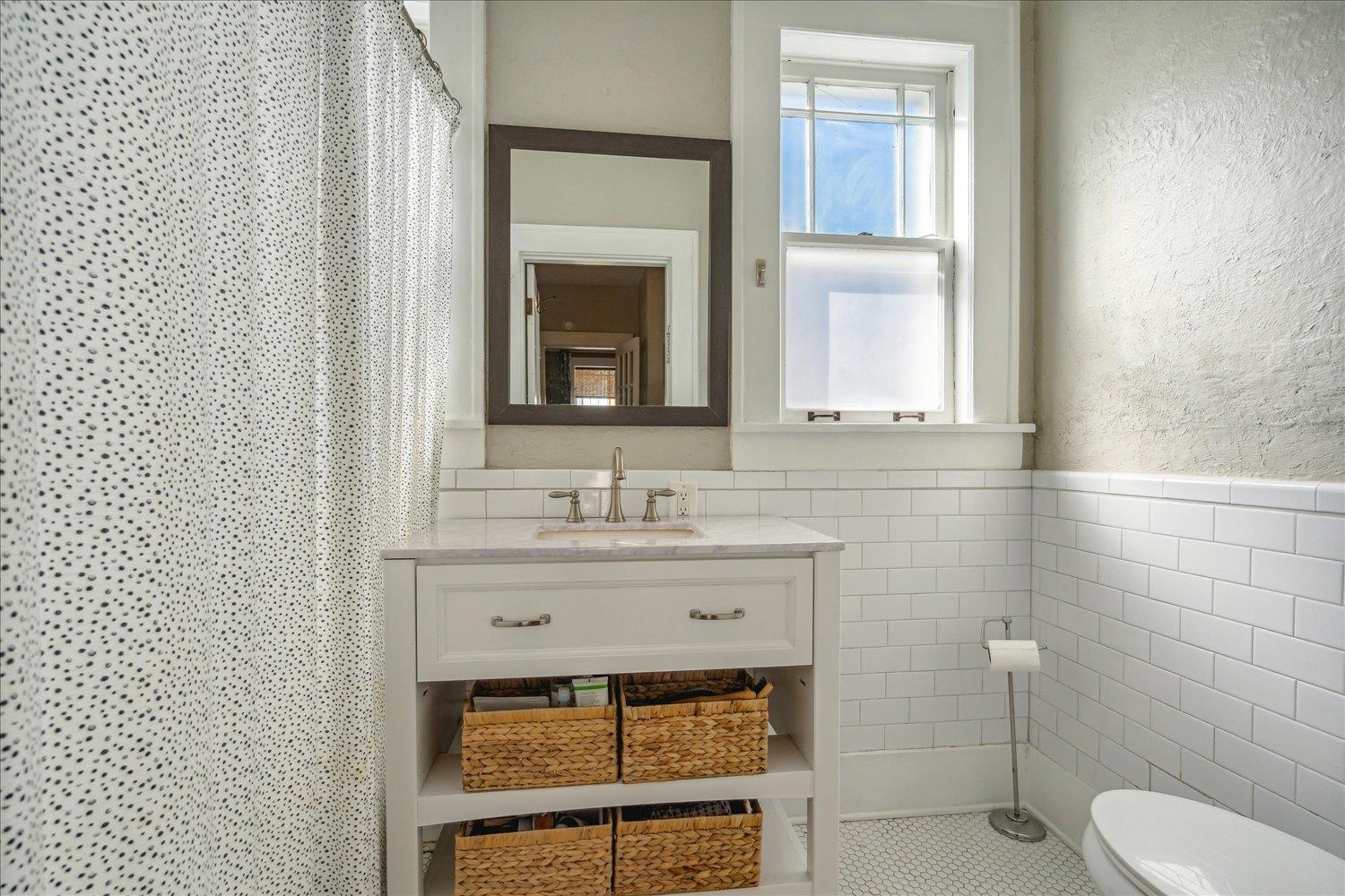 Bathroom featuring vanity, tile walls, and toilet