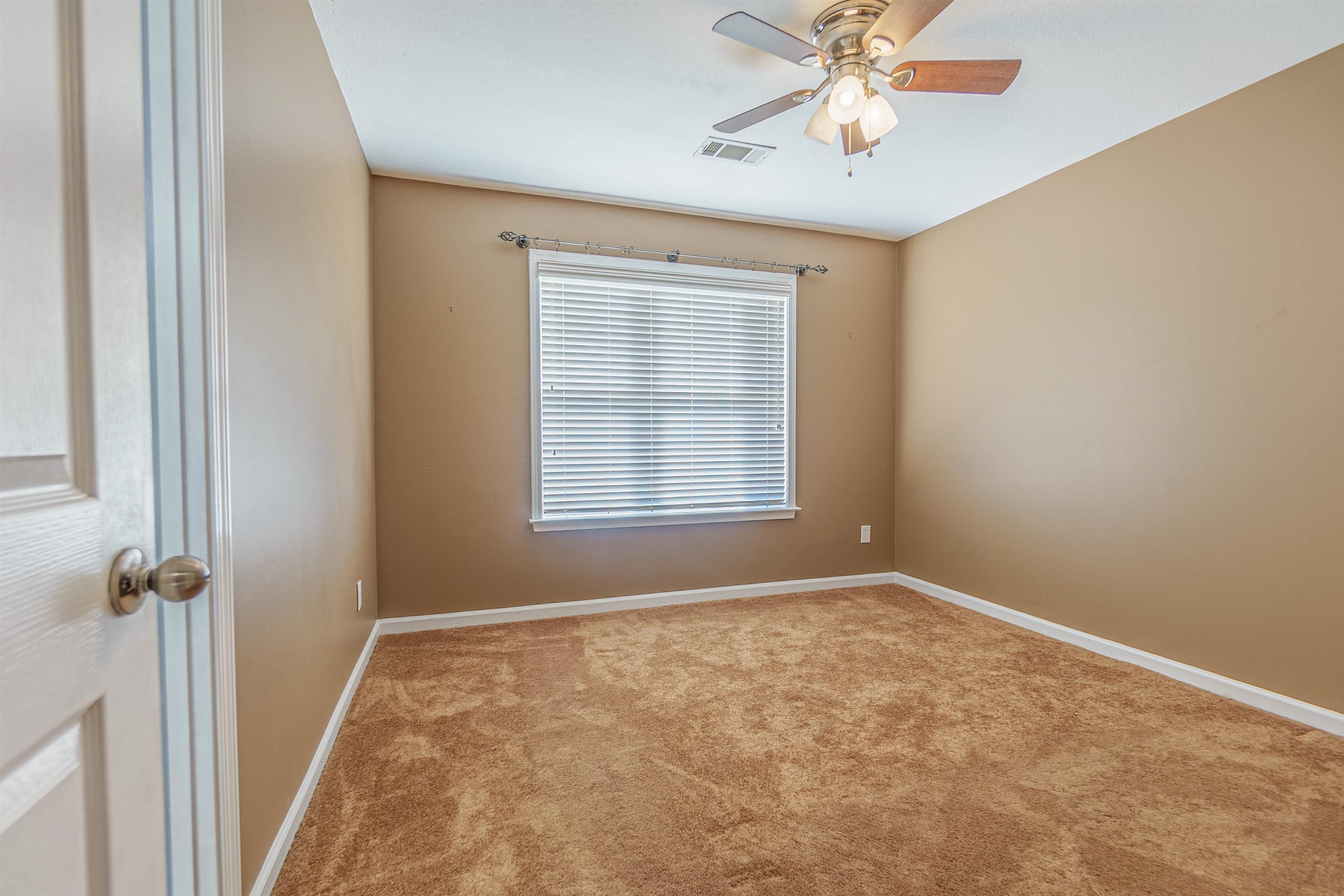 Empty room featuring light carpet and ceiling fan